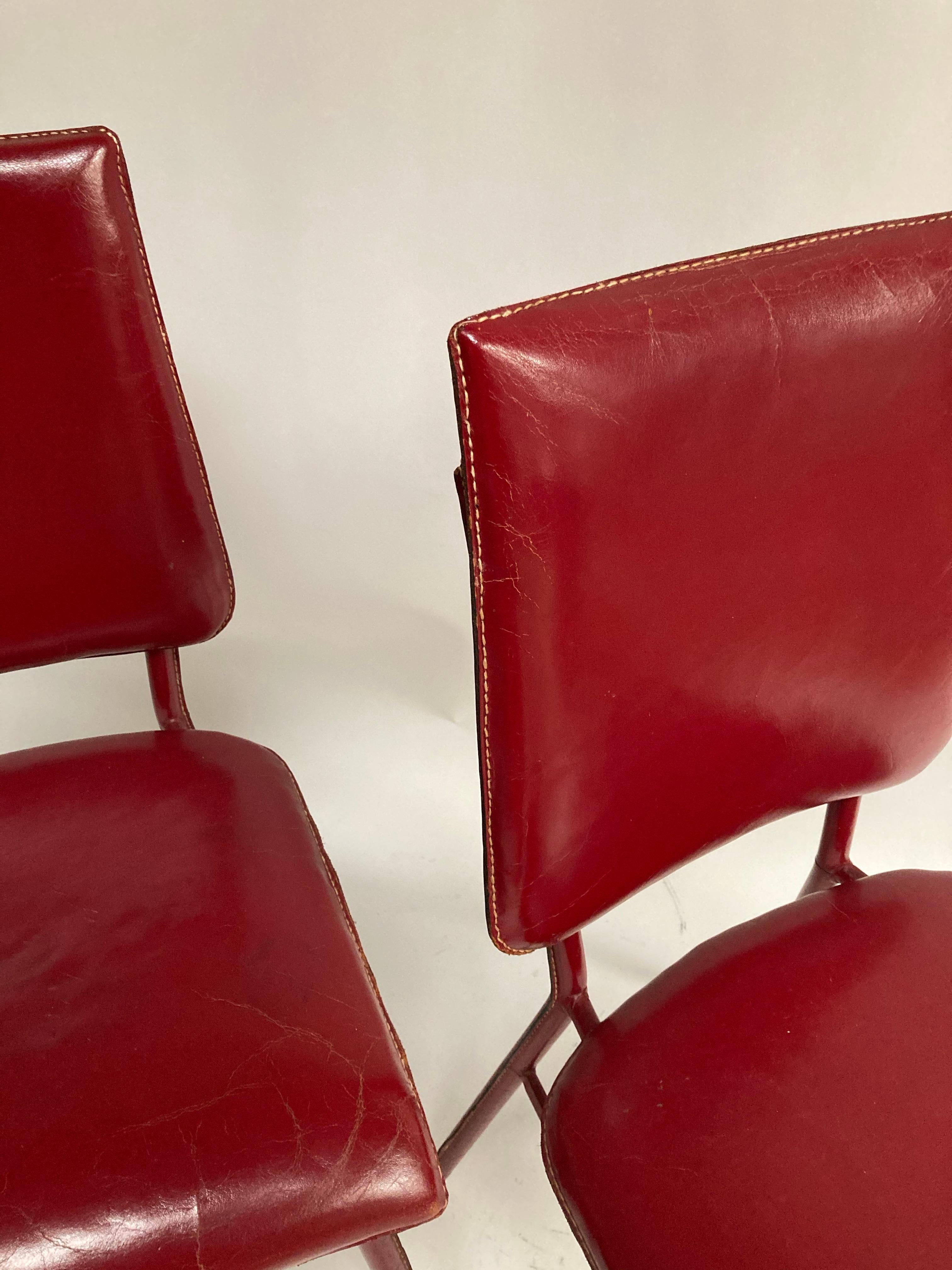 Paire de chaises en cuir rouge surpiqué des années 1950 par Jacques Adnet
France.