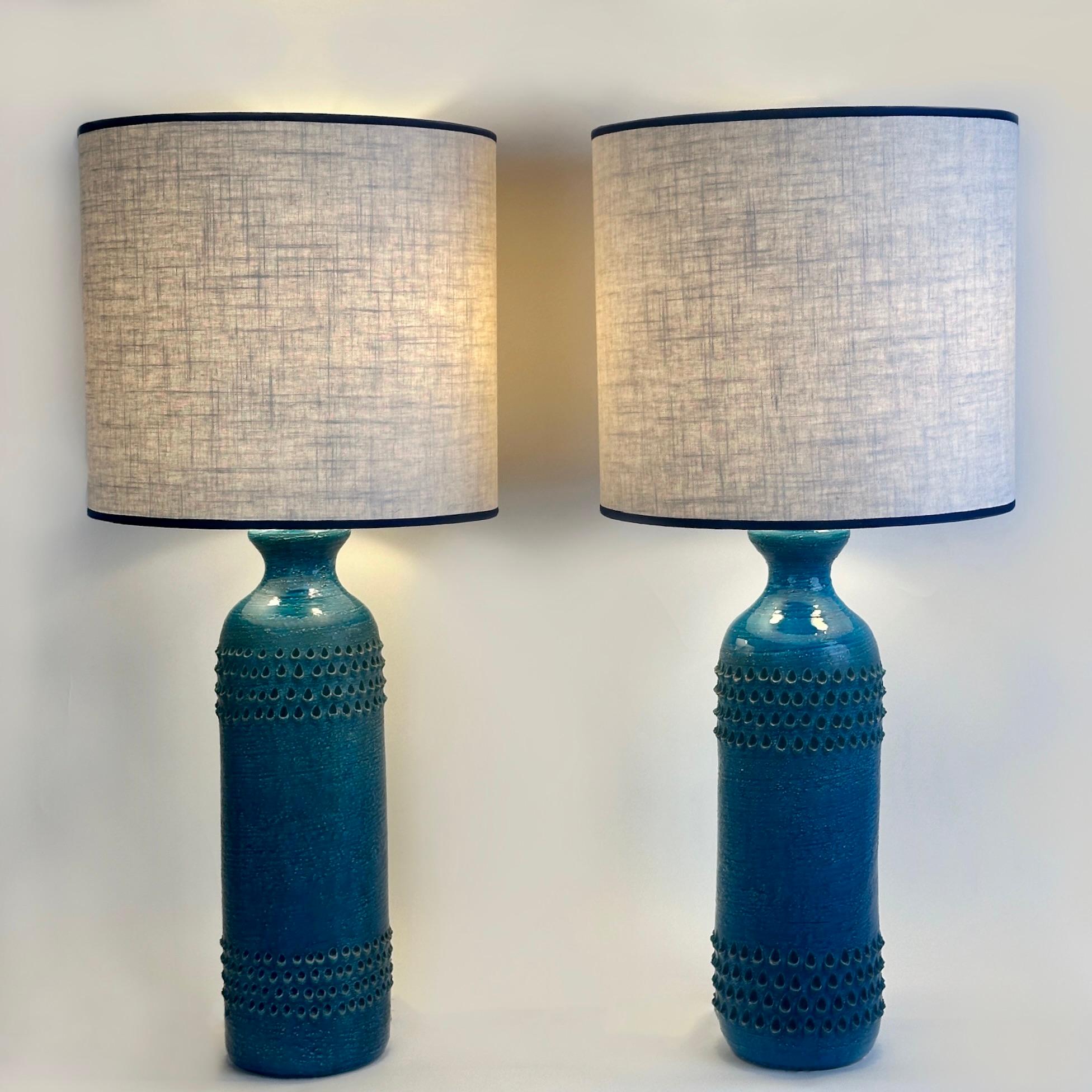 Stunning pair of handmade Rimini Blue table lamps signed on the bottom with cotton lampshades (size: 38 diam. x 35 H cm.). Two E27 light bulbs each. 

Aldo Londi (1911-2003) was a painter, sculptor and primarily ceramist. He created objects that are