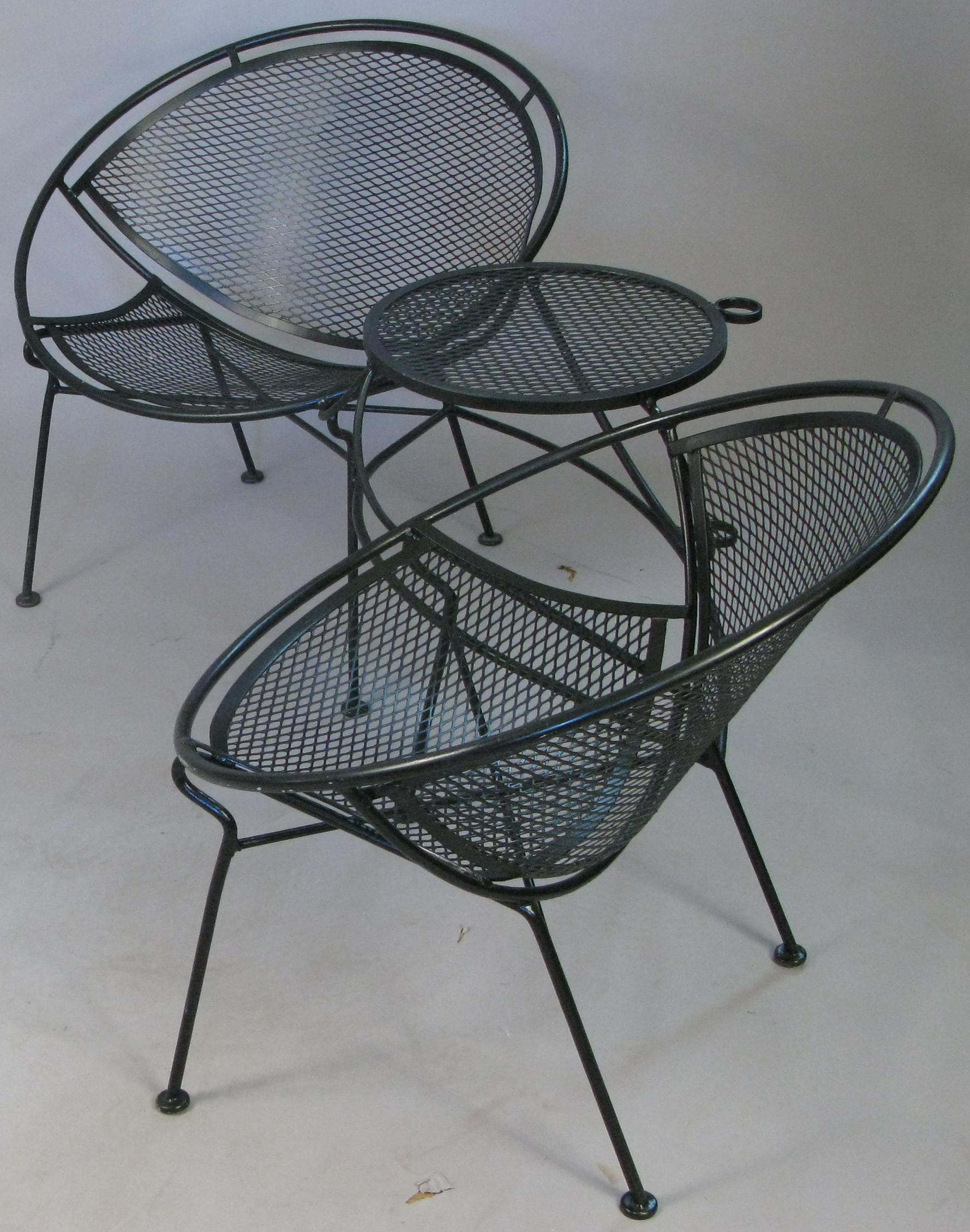 A matched pair of vintage 1950s tete a tetes from the Radar collection by Salterini, circa 1950, along with the companion cocktail table. Very comfortable and stylish, each tete a tetes has two lounge chairs connected by a table between, which also