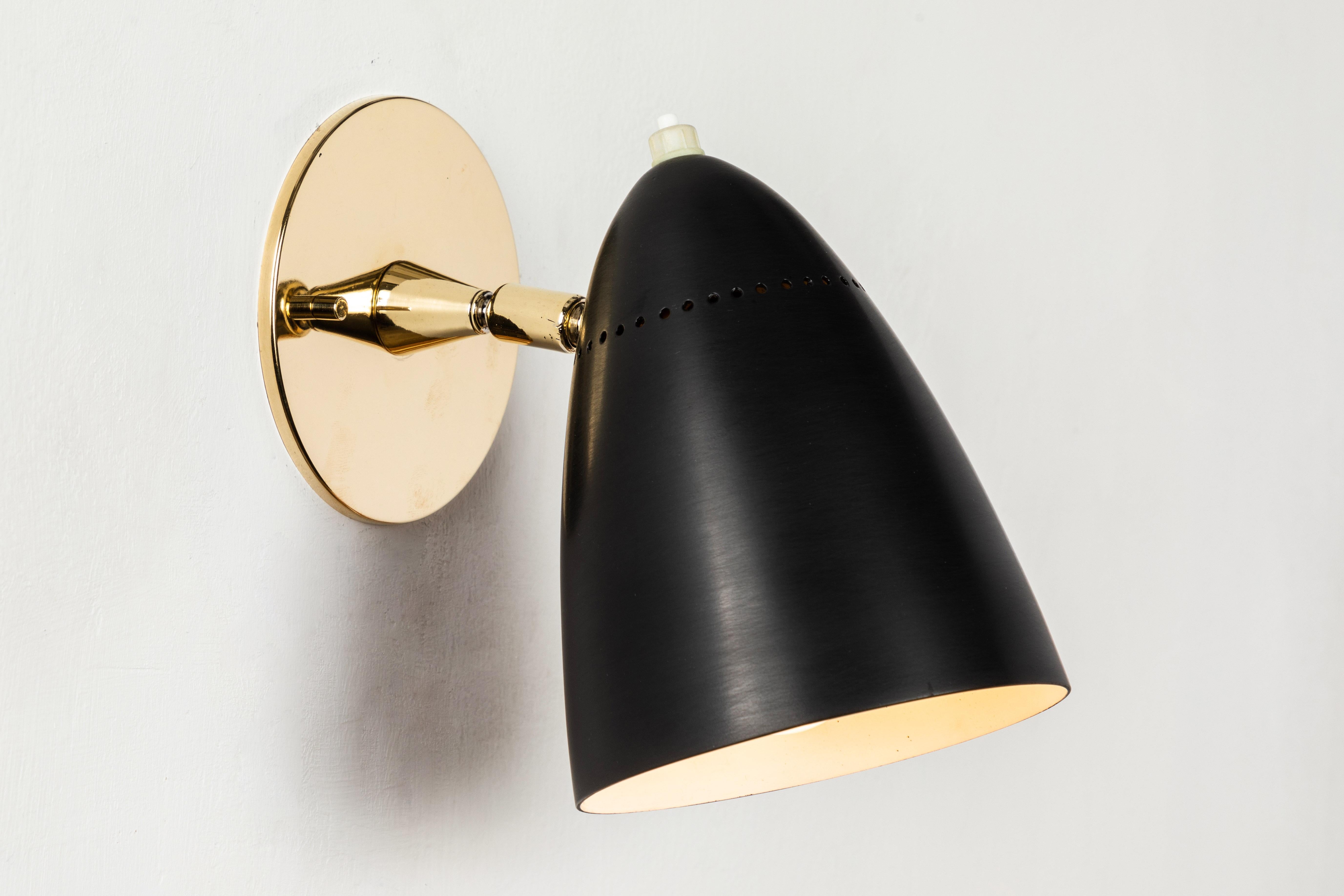 Pair of 1950s sconces by Gino Sarfatti for Arteluce. Executed in black painted aluminum and brass. Double ball jointed arm allows flexible shade adjustments and multiple configurations. The simplicity of Sarfatti's design and the sculptural shaping