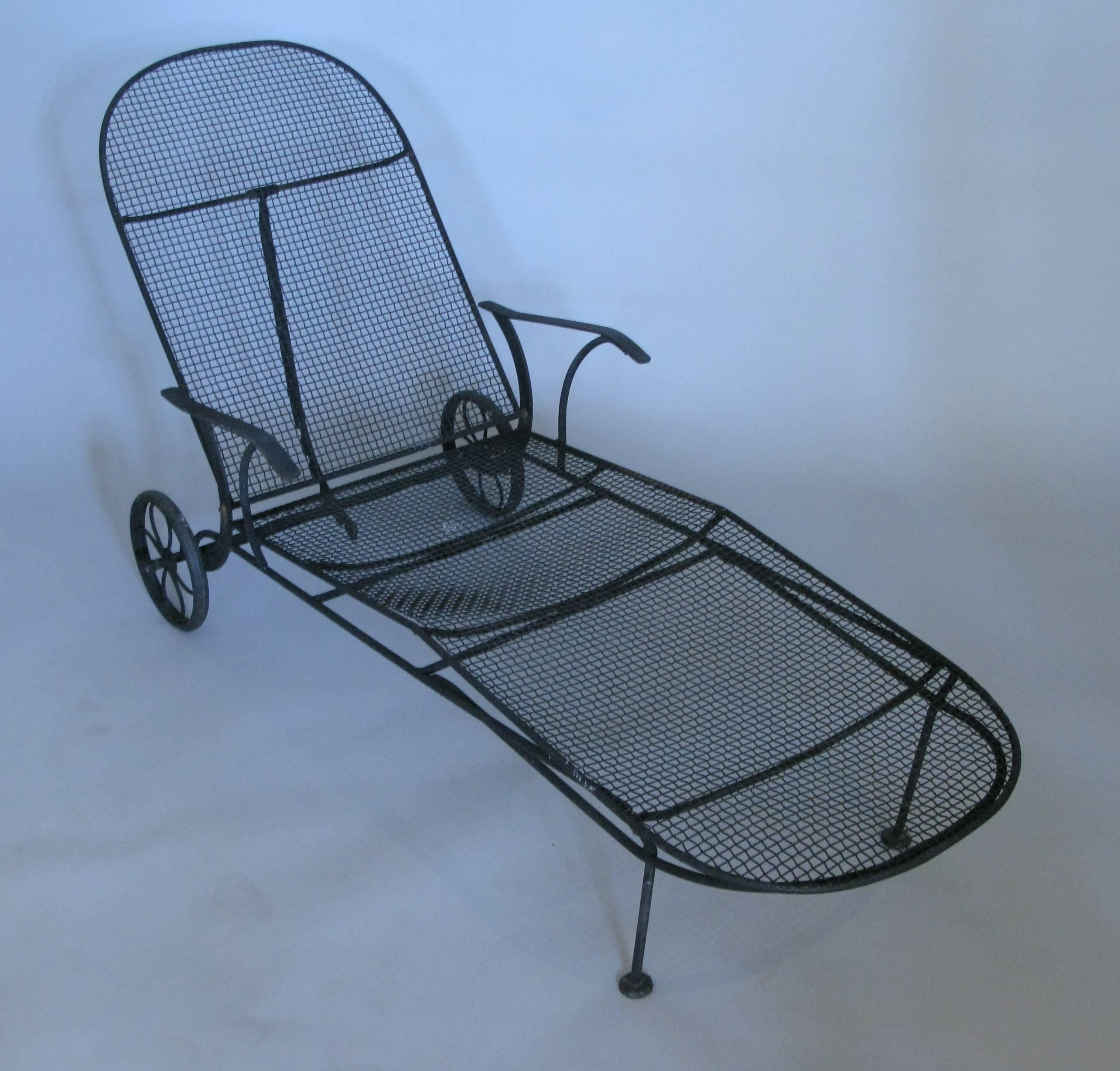 A pair of garden adjustable chaise lounges with wrought iron frames and woven steel mesh seats from Russell Woodard's sculptura collection, circa 1950s. With fully adjustable seat backs and wheels on the back for easy mobility. Can be finished in