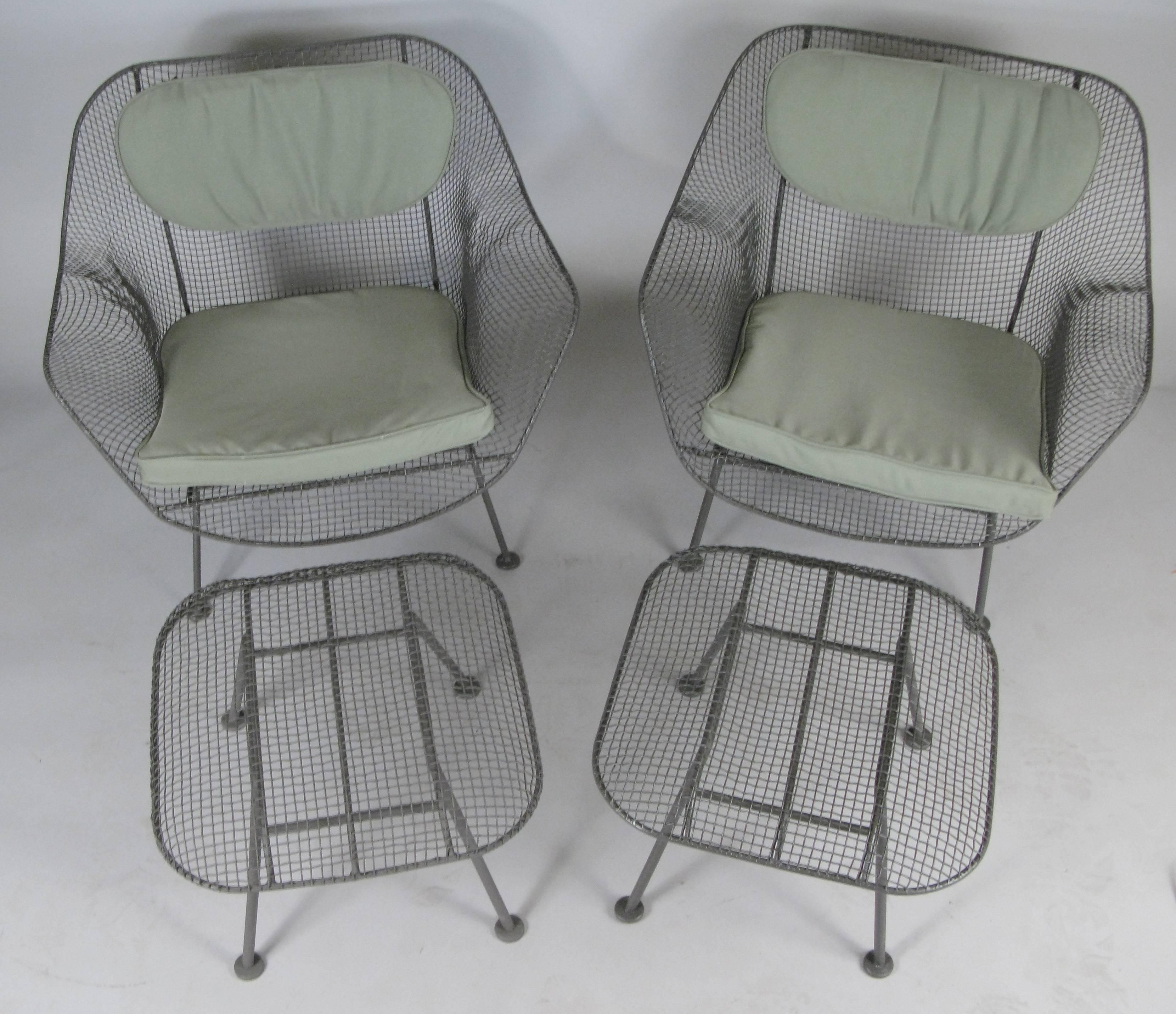 A pair of 'Sculptura' collection garden lounge chairs and matching ottomans all designed by Russell Woodard and made in the 1950s. Woodard's Sculptura collection was made with wrought iron frames and woven steel mesh seats. These are the largest