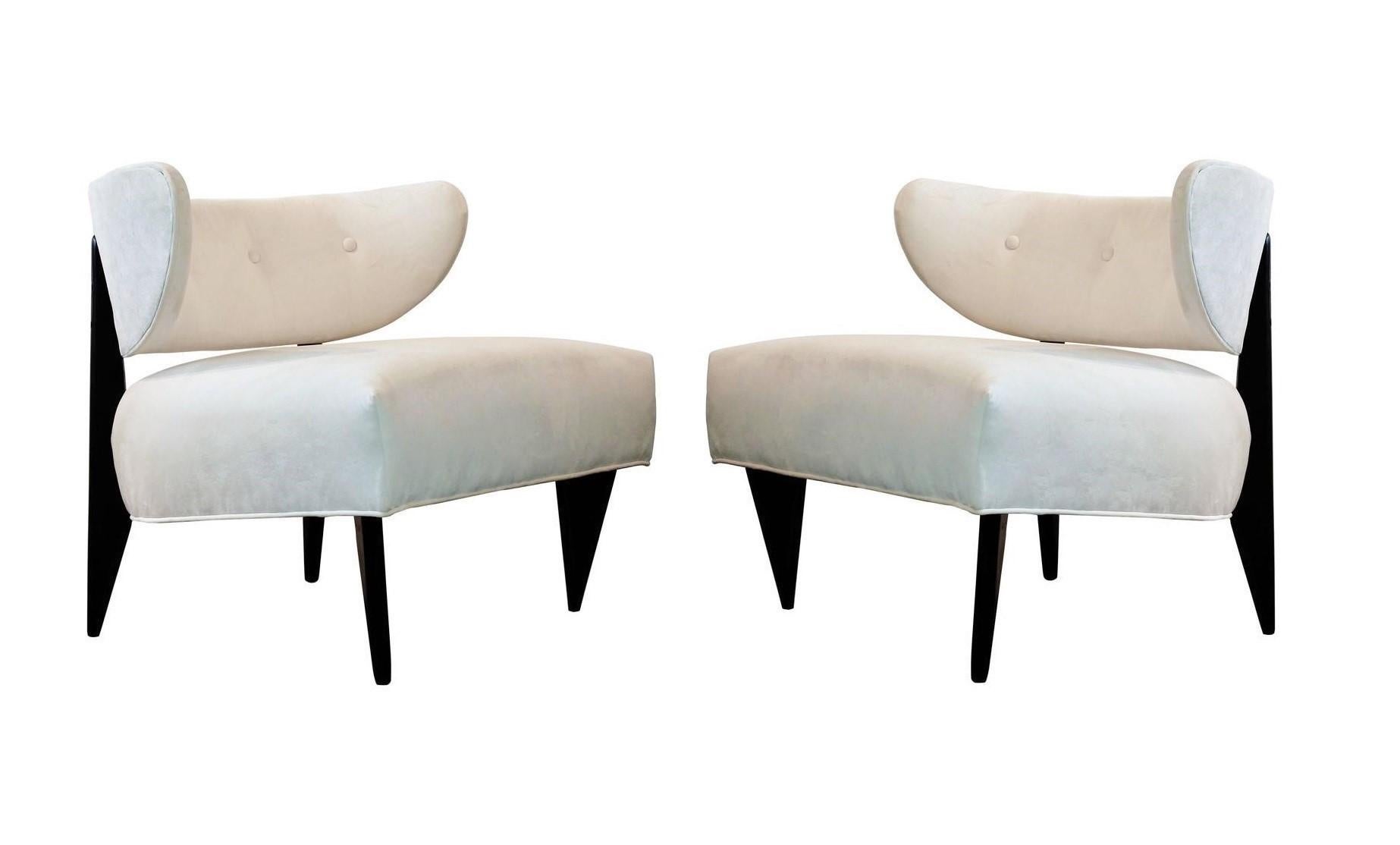 Offered is a stunning pair of Art Deco club / lounge chairs, circa 1950's. Visually captivating from every angle with their sensual curves and distinctive sharp tapered legs. Restored to mint condition. Highly sculptural frames with beautiful button
