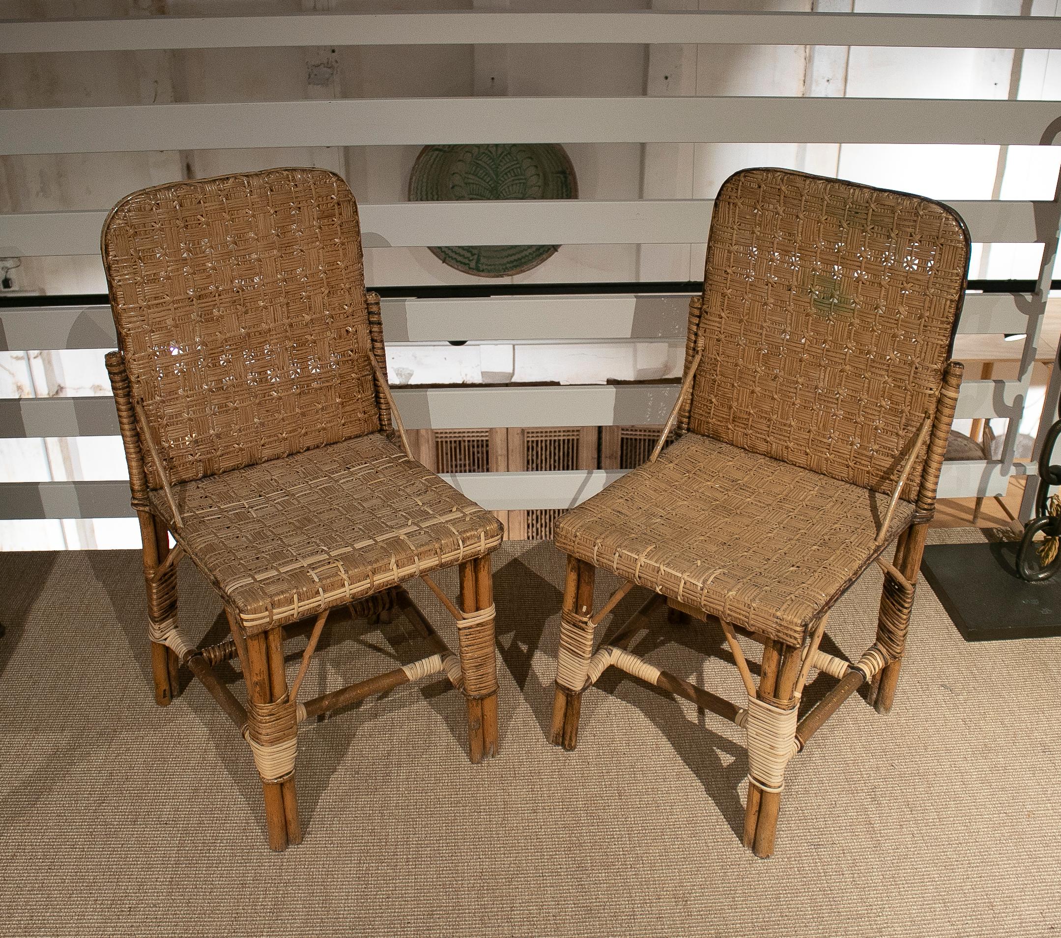 Pair of vintage 1950s Spanish hand woven wicker on wood chairs.