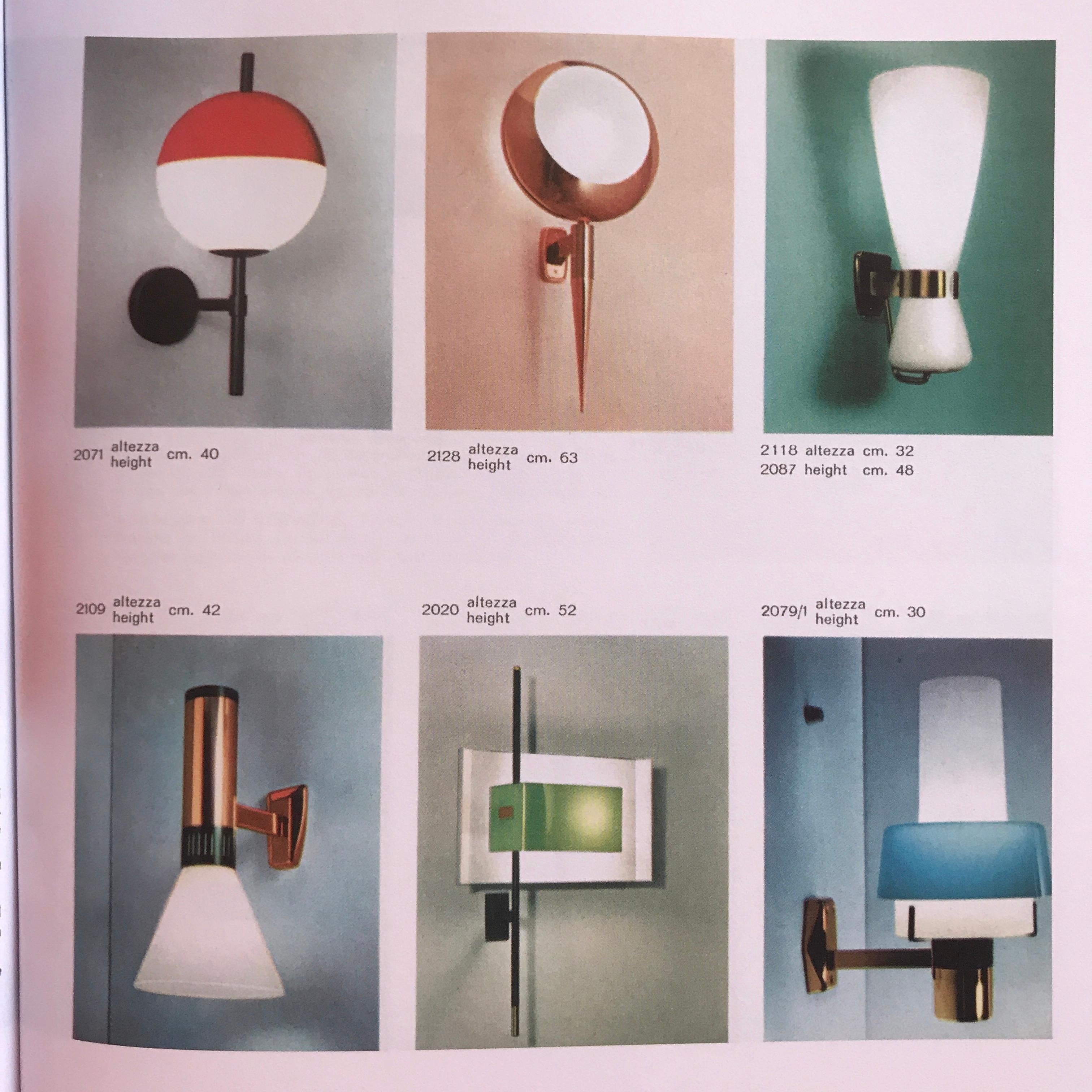 Coppia di appliques in ottone e vetro Stilnovo Modello 2079/1 degli anni '50 con etichette originali. Realizzato in ottone, vetro opalino spesso e perspex rosso, conserva l'etichetta originale Stilnovo. Un design scultoreo e raffinato,