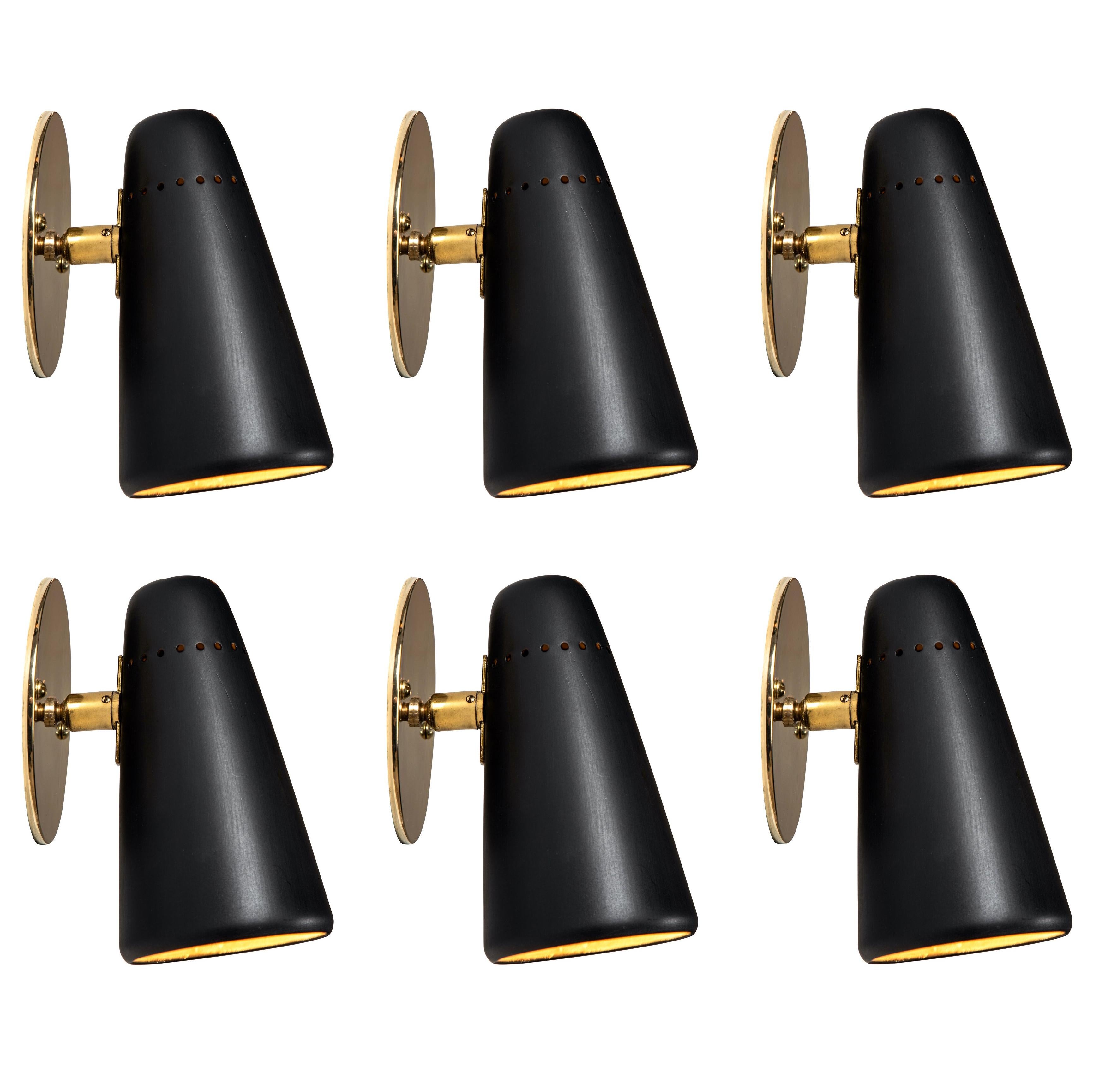 Pair of 1950s Stilnovo adjustable sconces in black and brass. A quintessentially 1950s Italian design executed in black painted metal with custom brass backplates for mounting over a standard American juncture box. Shades can be rotated freely on a