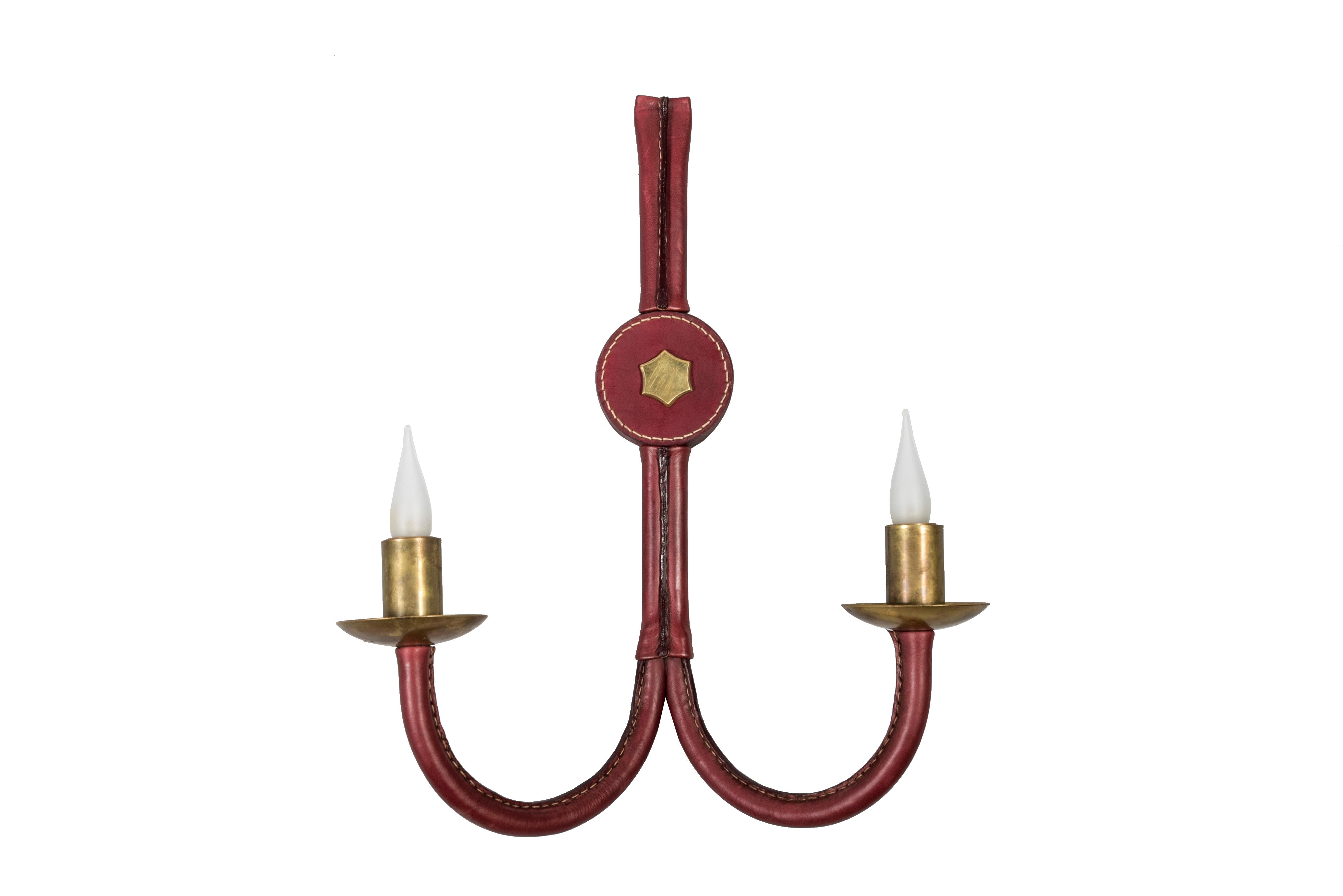 Very nice pair of tall Jacques Adnet stitched leather sconces
burgundy leather and brass star.