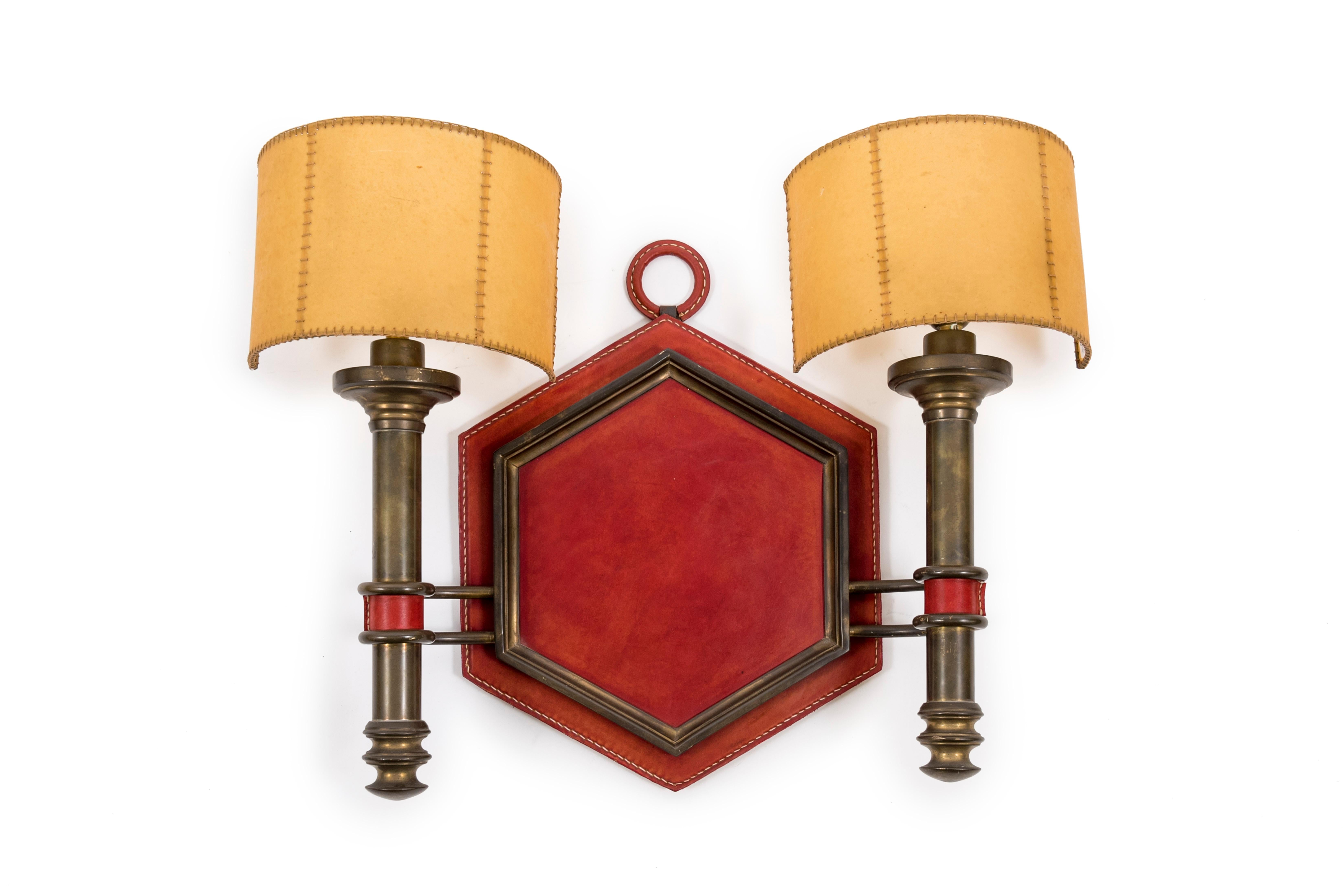 Incredible pair of Stitched leather sconces designed by Jacques Adnet.
Parchment shade.
Very good condition.
2 bulbs international E27.
Newly rewired.
Dimensions given without shade
 