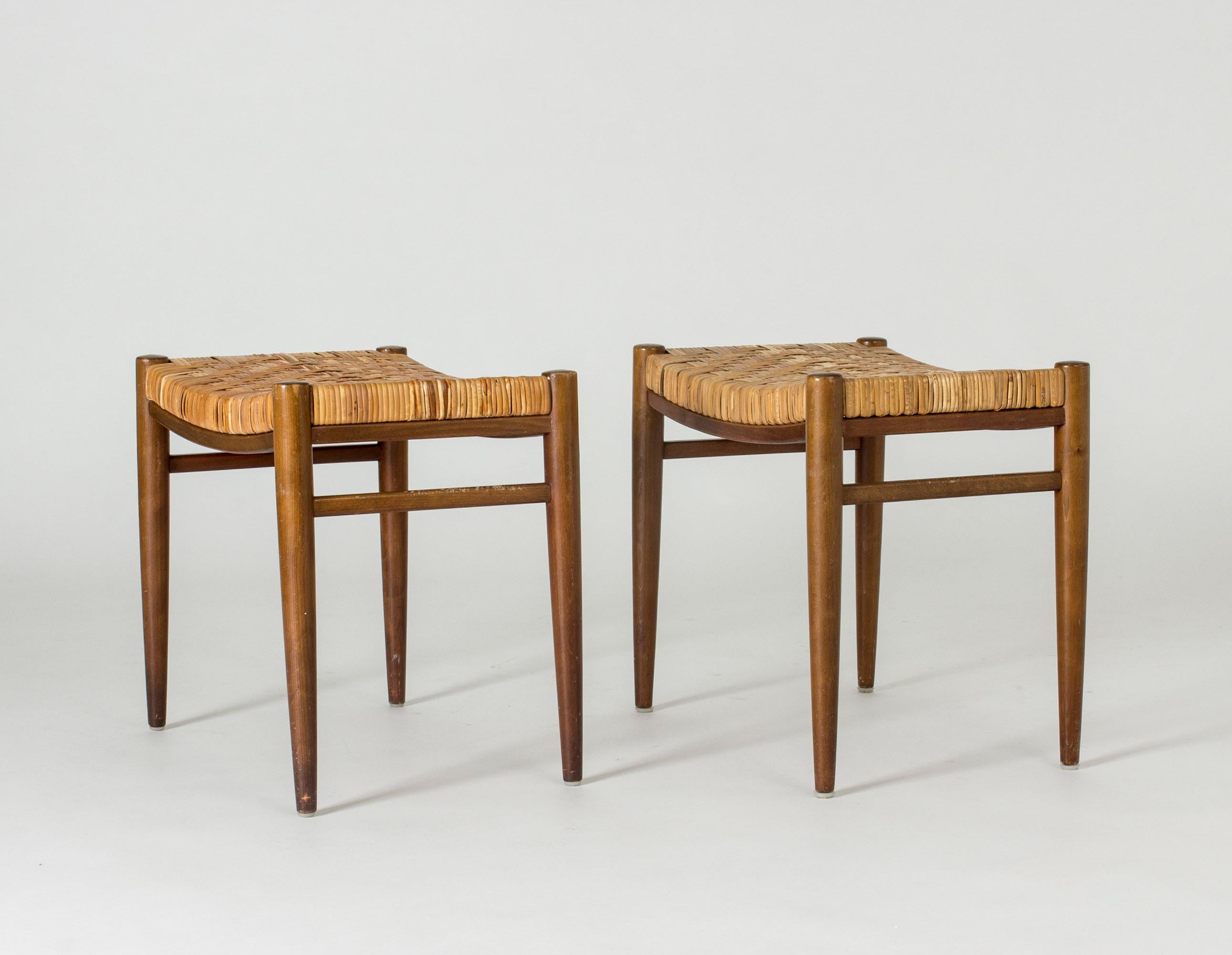 Pair of beautiful Swedish 1950s stools with rattan seats. Rattan woven in a snug, graphic pattern.