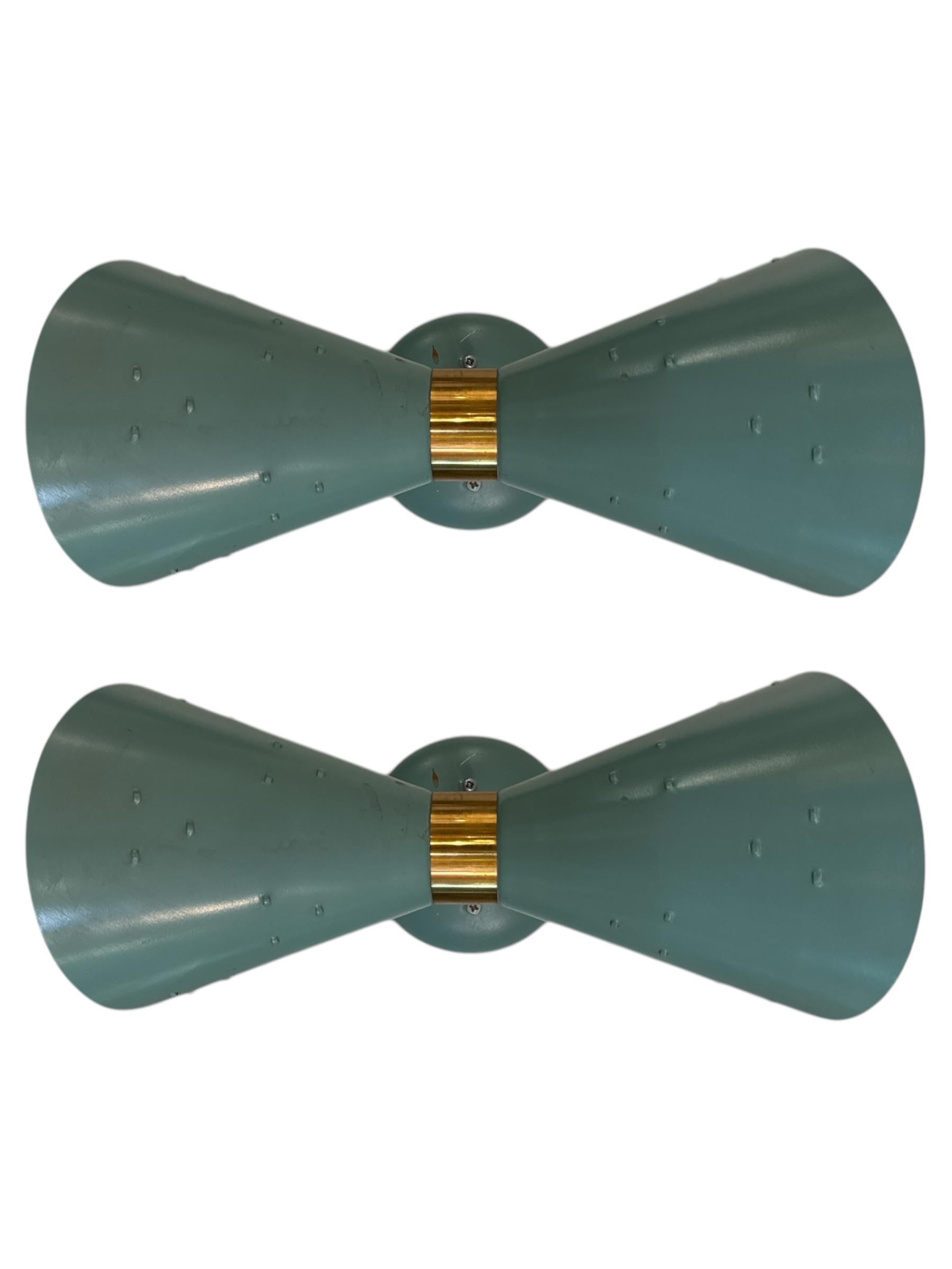 Introduce a touch of mid-century elegance to your space with this stunning Pair of 1950s Tiffany Blue Brass Double Cone Sconces. These sconces beautifully blend vintage charm with modern flair, making them a perfect choice for anyone seeking a