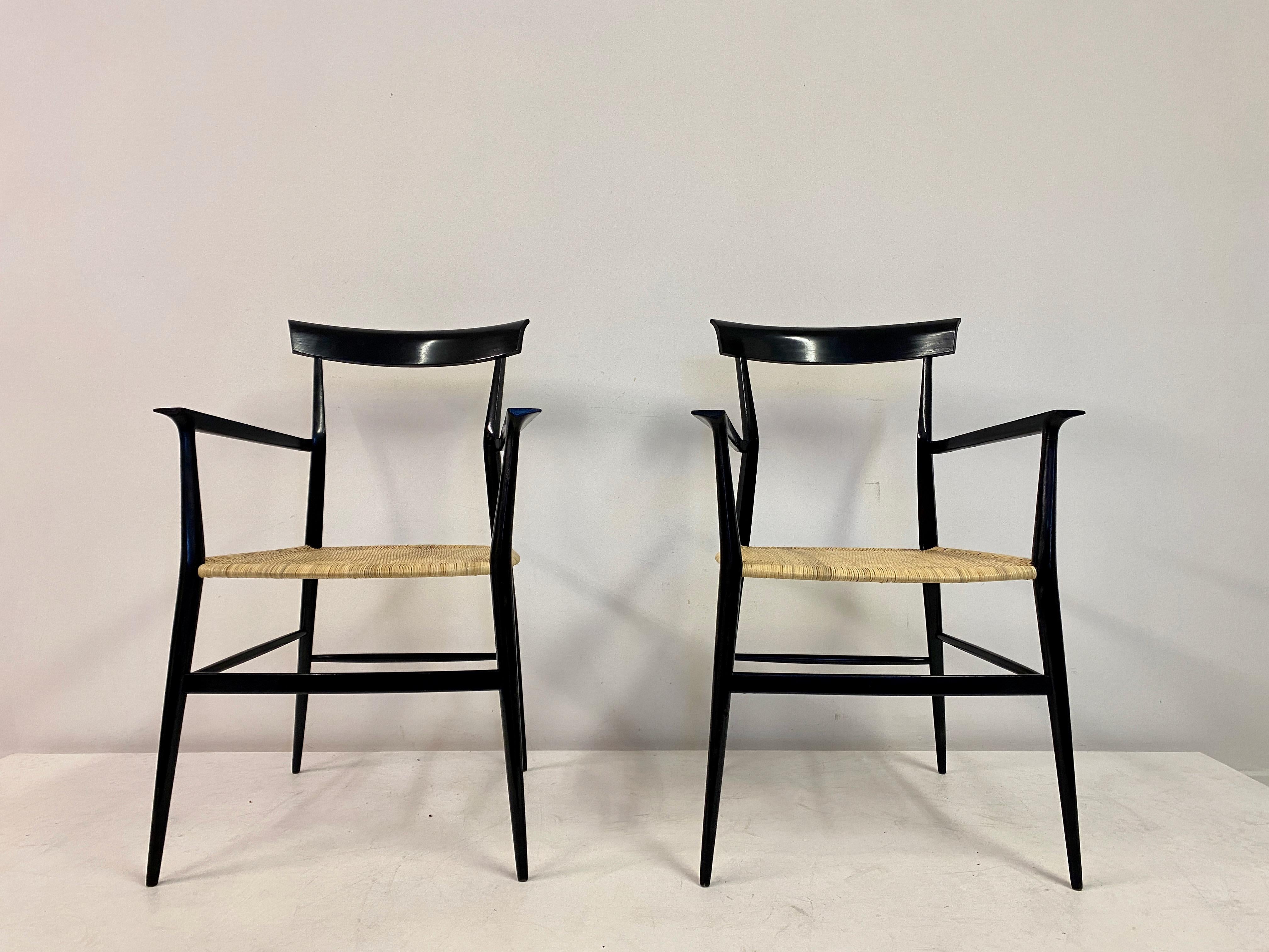 Pair of armchairs

Tigullina model

By Colombo Sanguineti

Black lacquered beech

New woven reeded seats 

Slender frame and extremely light

On round in section legs.

 Back uprights with a deep overhanging back top splat

Flat arms