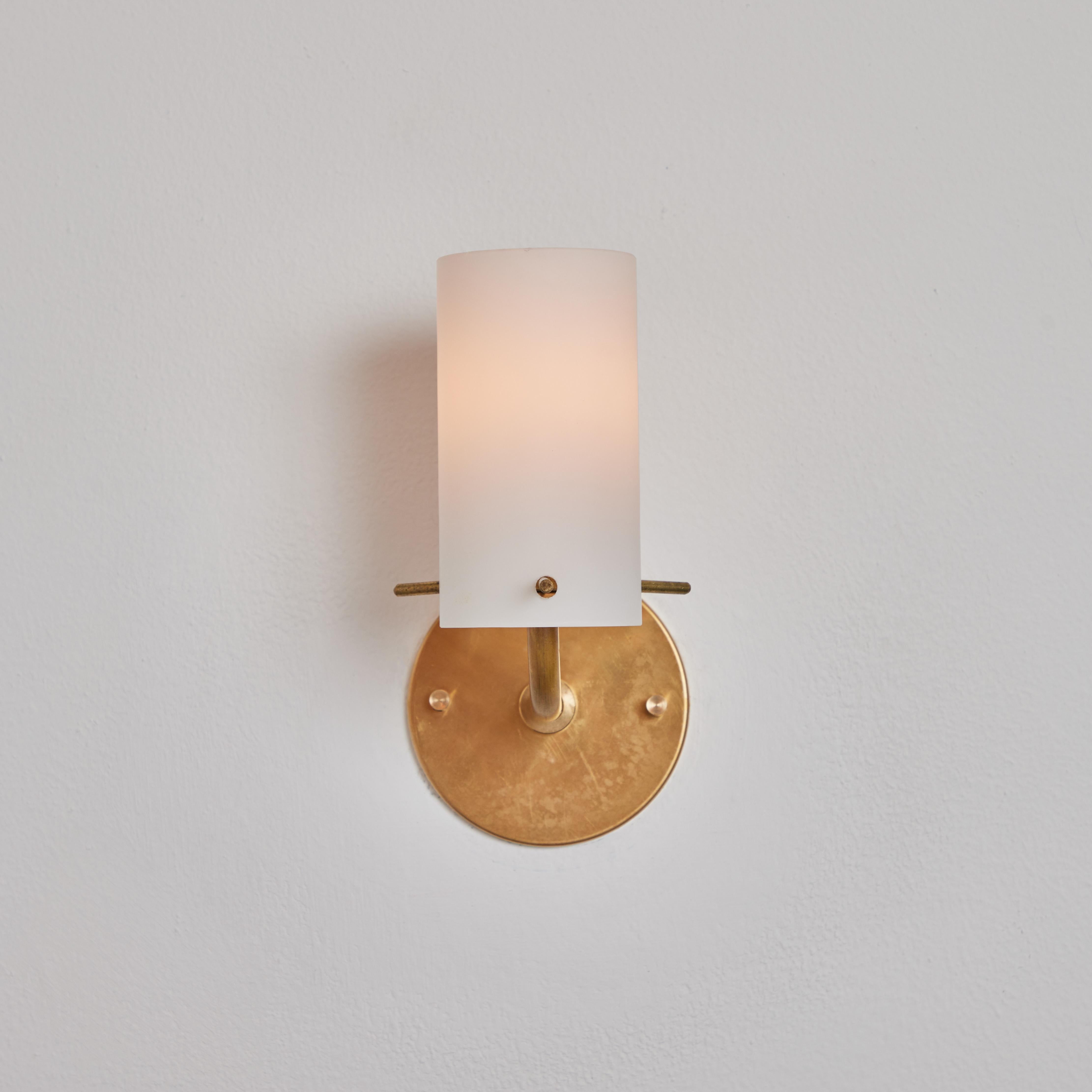 Pair of 1950s Tito Agnoli brass & glass cylindrical wall lamps for O-Luce. Executed in opaline glass and brass. An incredibly clean and refined design by one of the greatest Italian lighting icons of the modern age.

Price is for the pair.