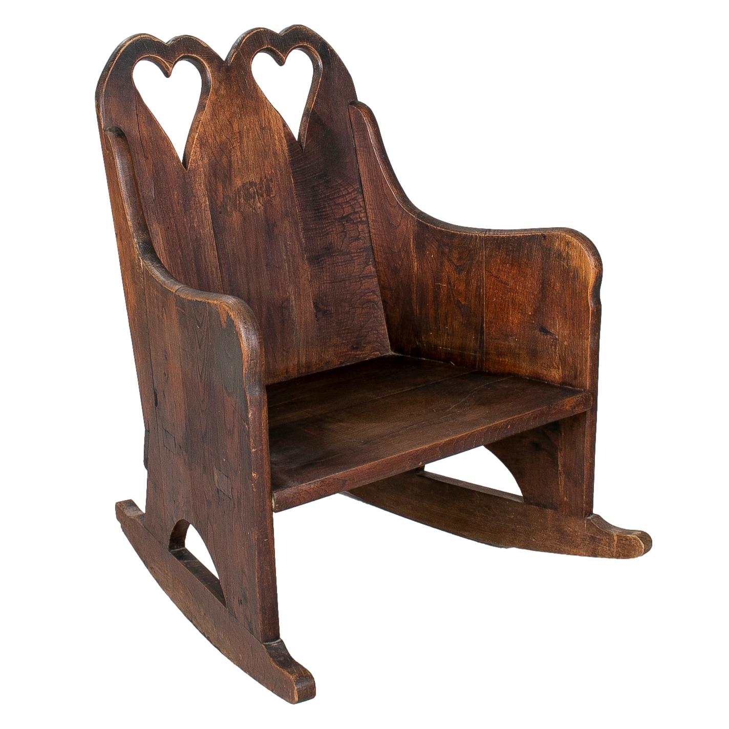 Pair of 1950s hand carved traditional Austrian Tyrolean wooden rocking chairs with two hearts on back rests.