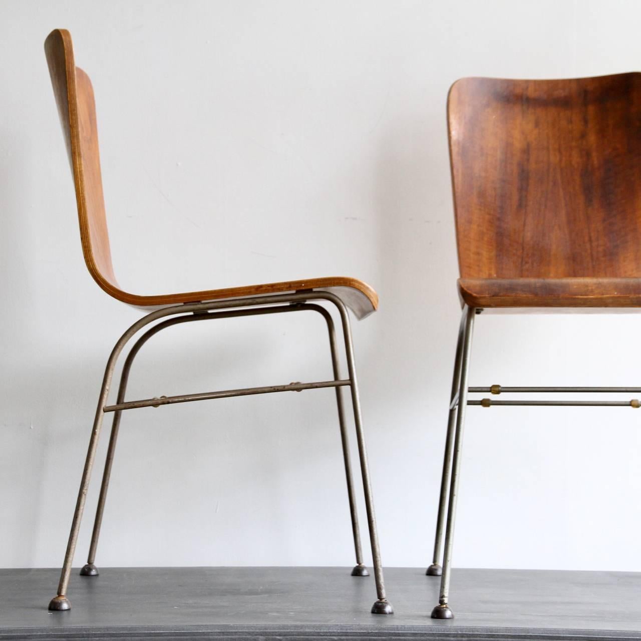 A pair of 1950s wire frames bent laminate walnut chairs on Armstrong Cork Co Bakelite feet. In the style of Olavi Kettunen. 
One of the chairs is missing a foot see photos. A replacement could be made.