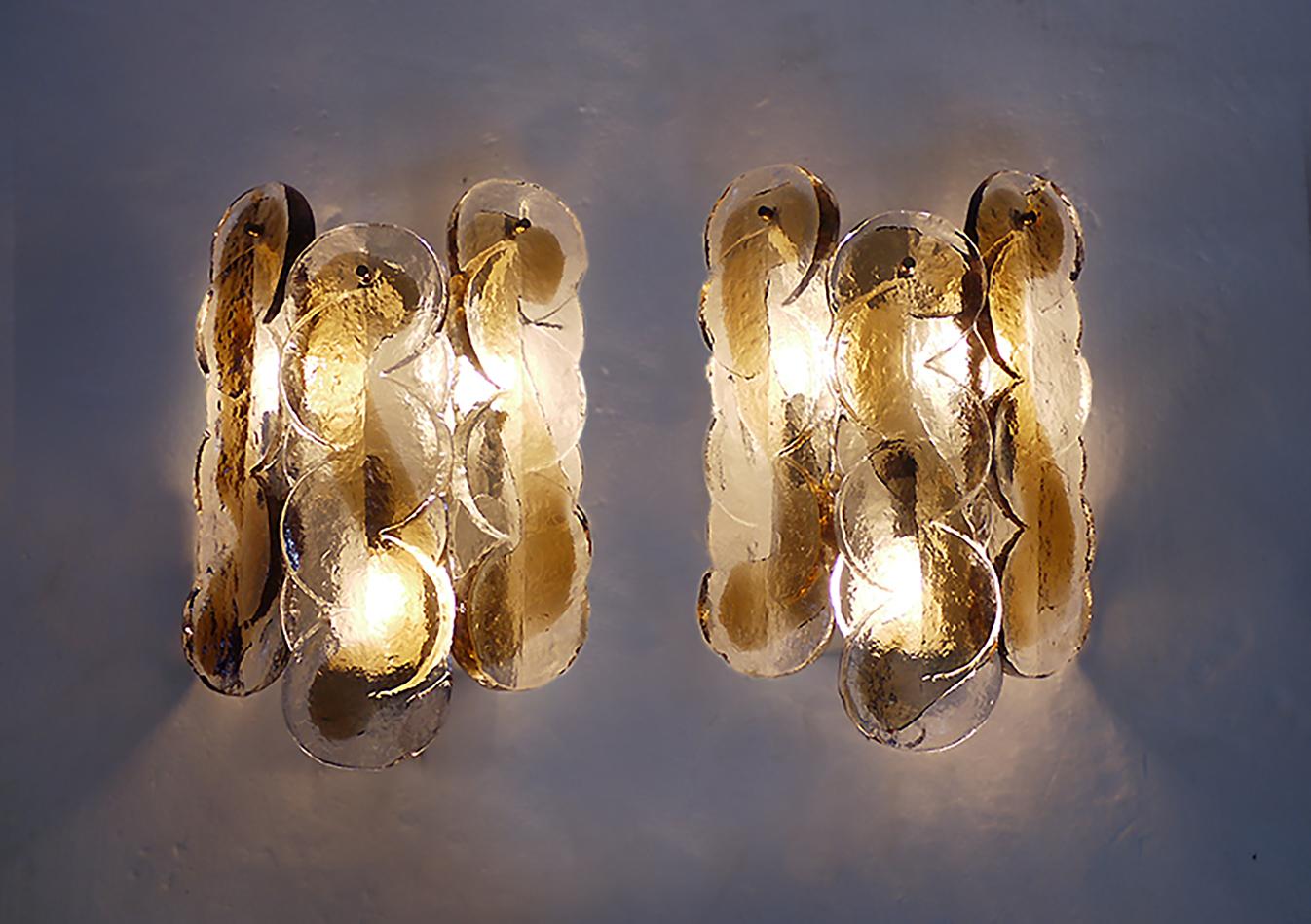 Elegantes Set aus zwei schönen J.T. Kalmar 'Citrus' Wandleuchten mit drei Gläsern mit Wirbelmuster pro Leuchte. Die schweren mundgeblasenen bernsteinfarbenen und klaren Murano-Gläser haben rauchfarbene Akzente.

Hergestellt in der Mitte des
