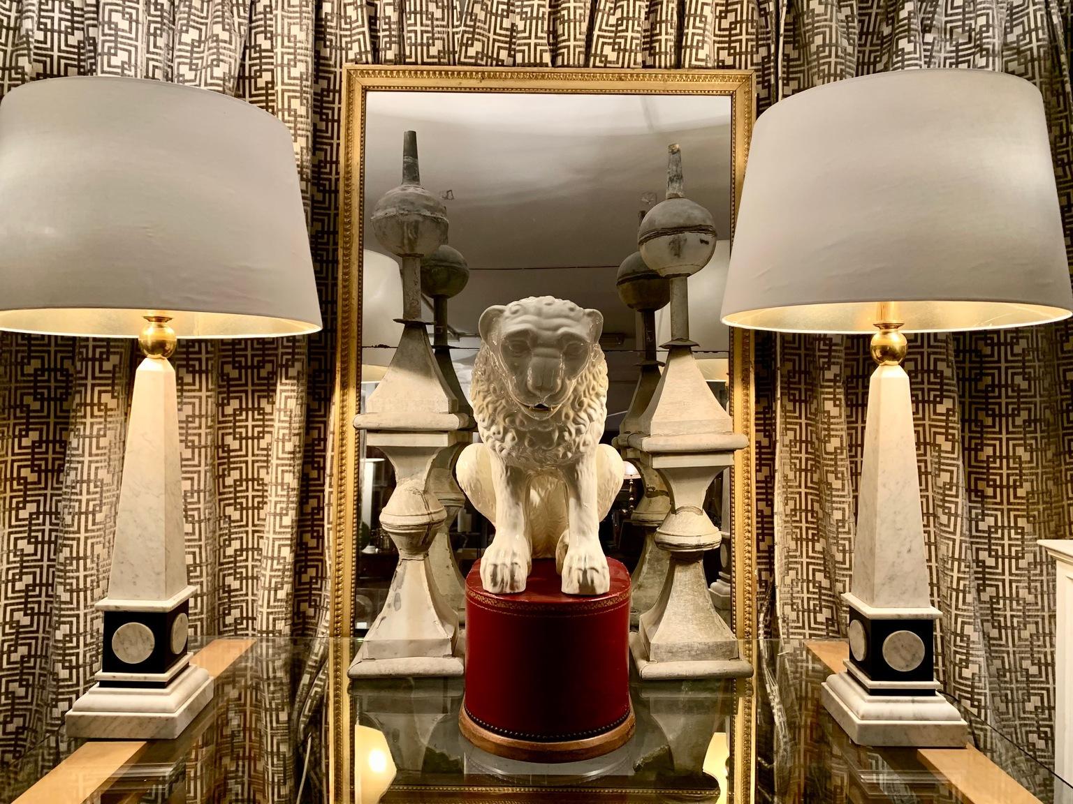 Pair of large obelisk-shaped lamps, in marble and black stone, each lamp has three bulbs, two on the sides and the other directed at the ceiling, coming out of a gilded brass column with a ball-shaped base. Measurements are for lamps only. The
