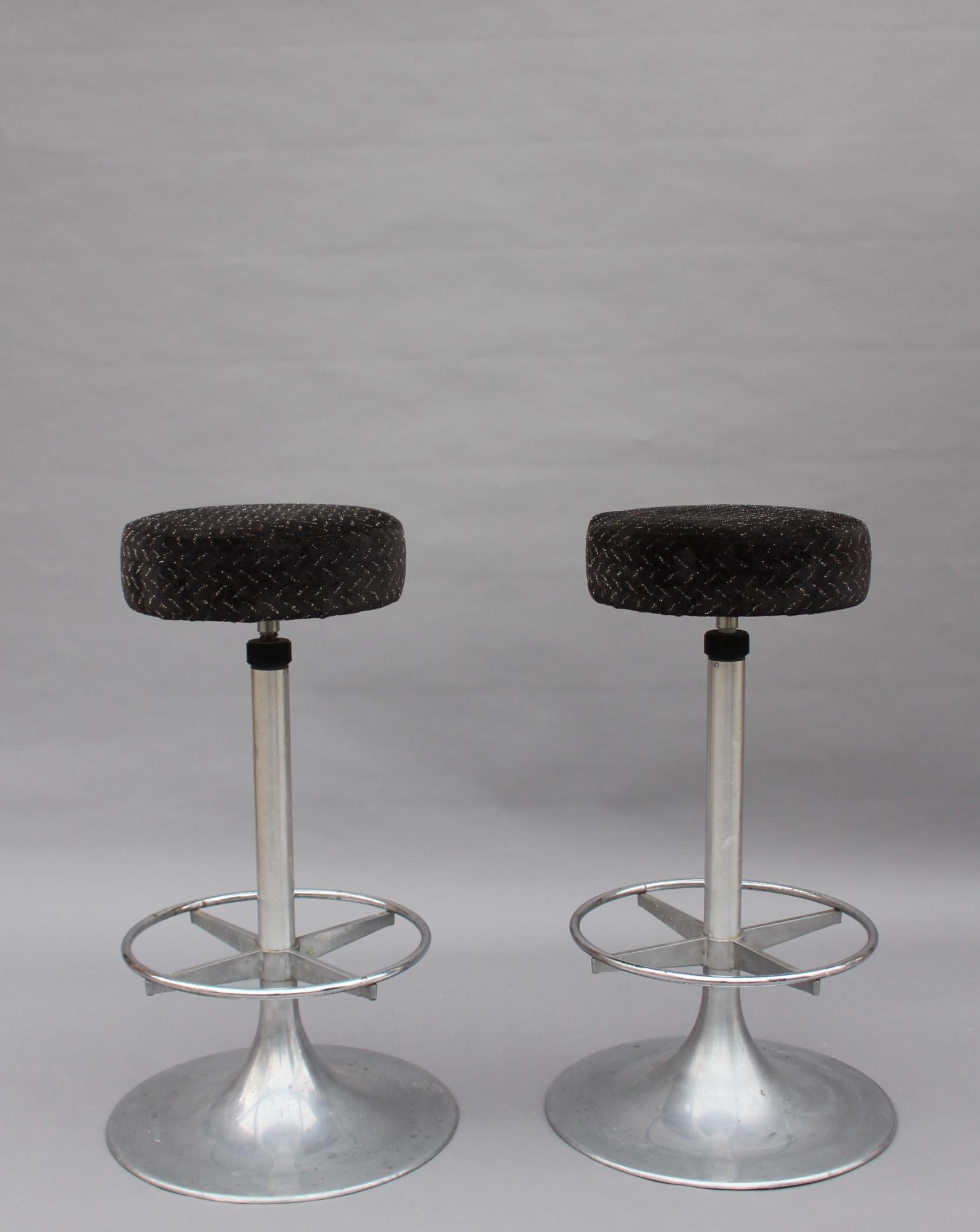 A pair of 1960s cast aluminum bar stools with chrome footrests 
Diameter of seat is 14 1/4
