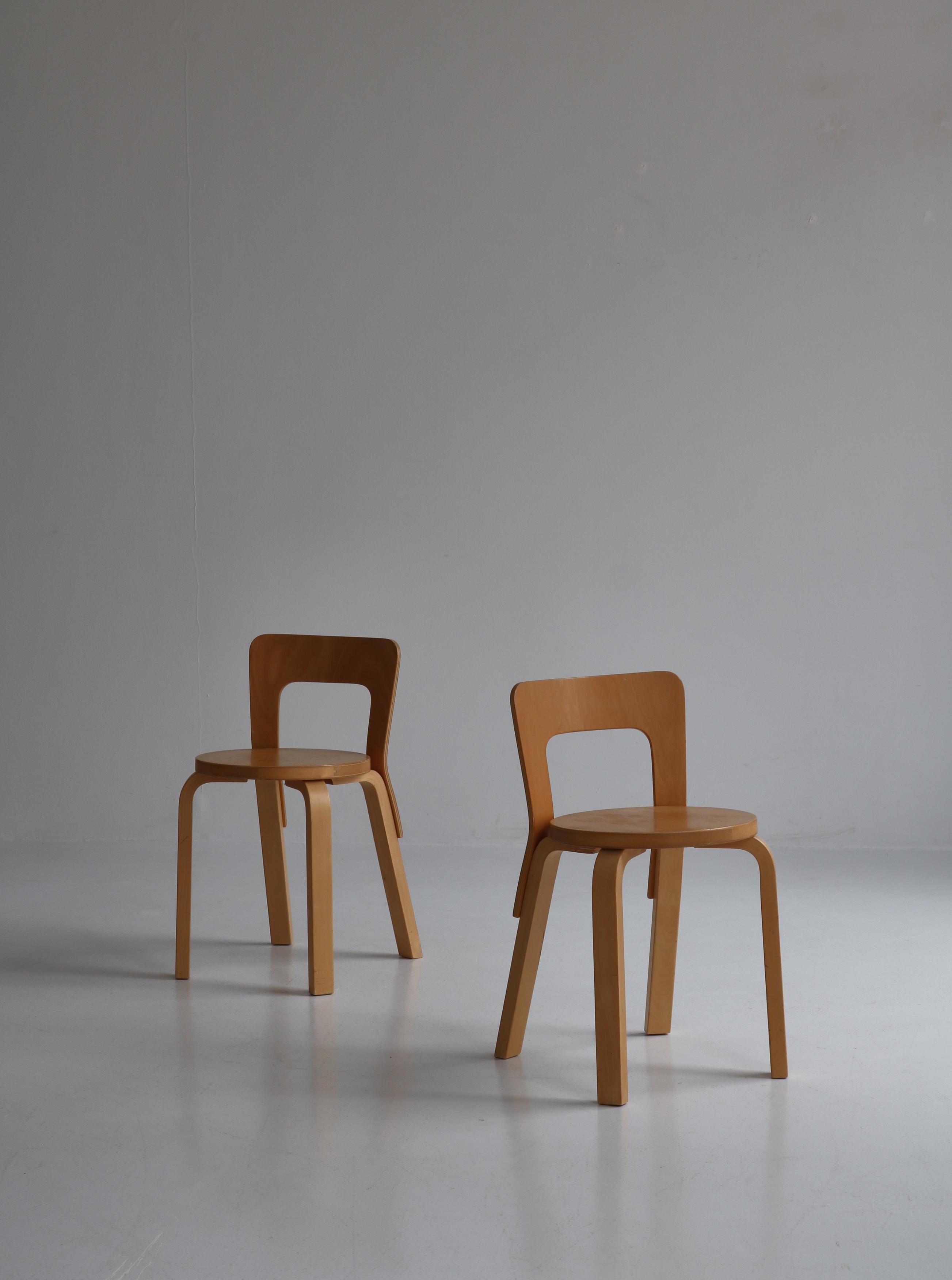 Pair of early production model 65 chair by Alvar Aalto. The chairs are made in laminated birch and have a beautiful glow and patina. Worn but without any structural damages. Clean lines and a simple structure define the design of Chair 65. A low,