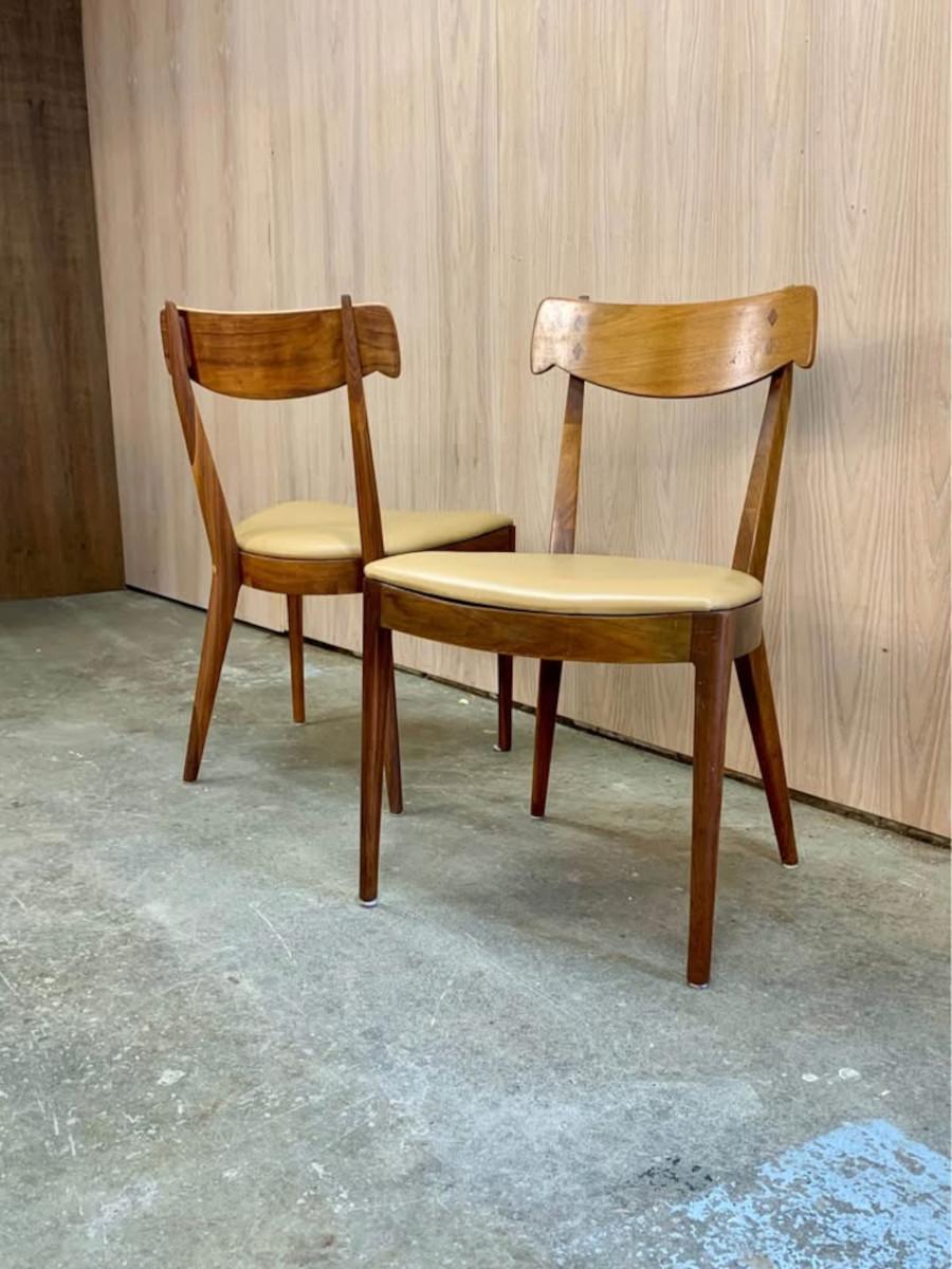 New to our collection, this striking pair of “Declaration” dining chairs, designed by Kipp Stewart in the 1960s, is a standout example of mid-century design. Crafted with solid walnut frames and accented by delicate rosewood details, their refined