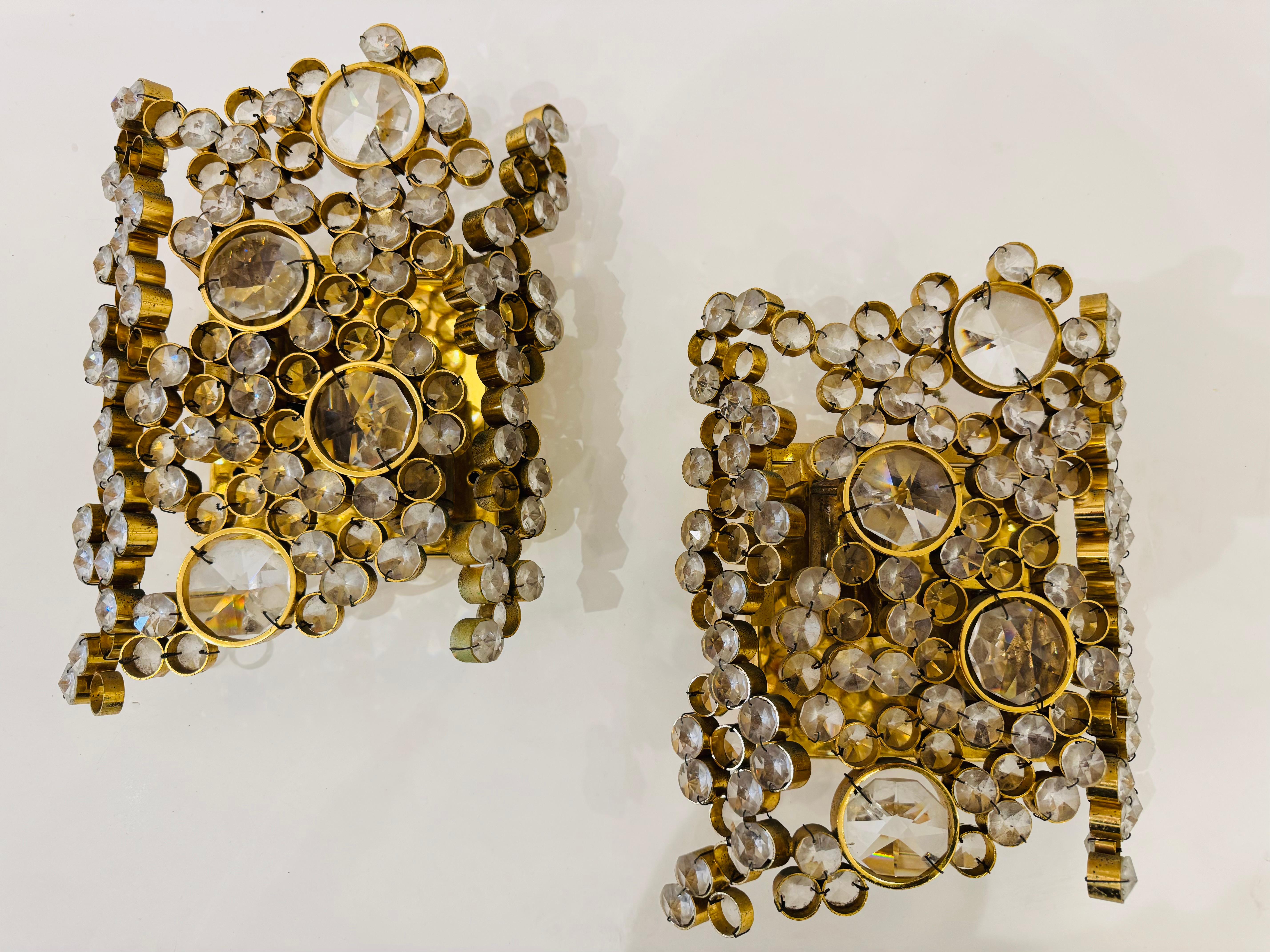 Una coppia di lussuose applique in cristallo austriaco della metà degli anni '60, incastonate in cornici dorate. Ricablati con 2 prese a candelabro ciascuno.

