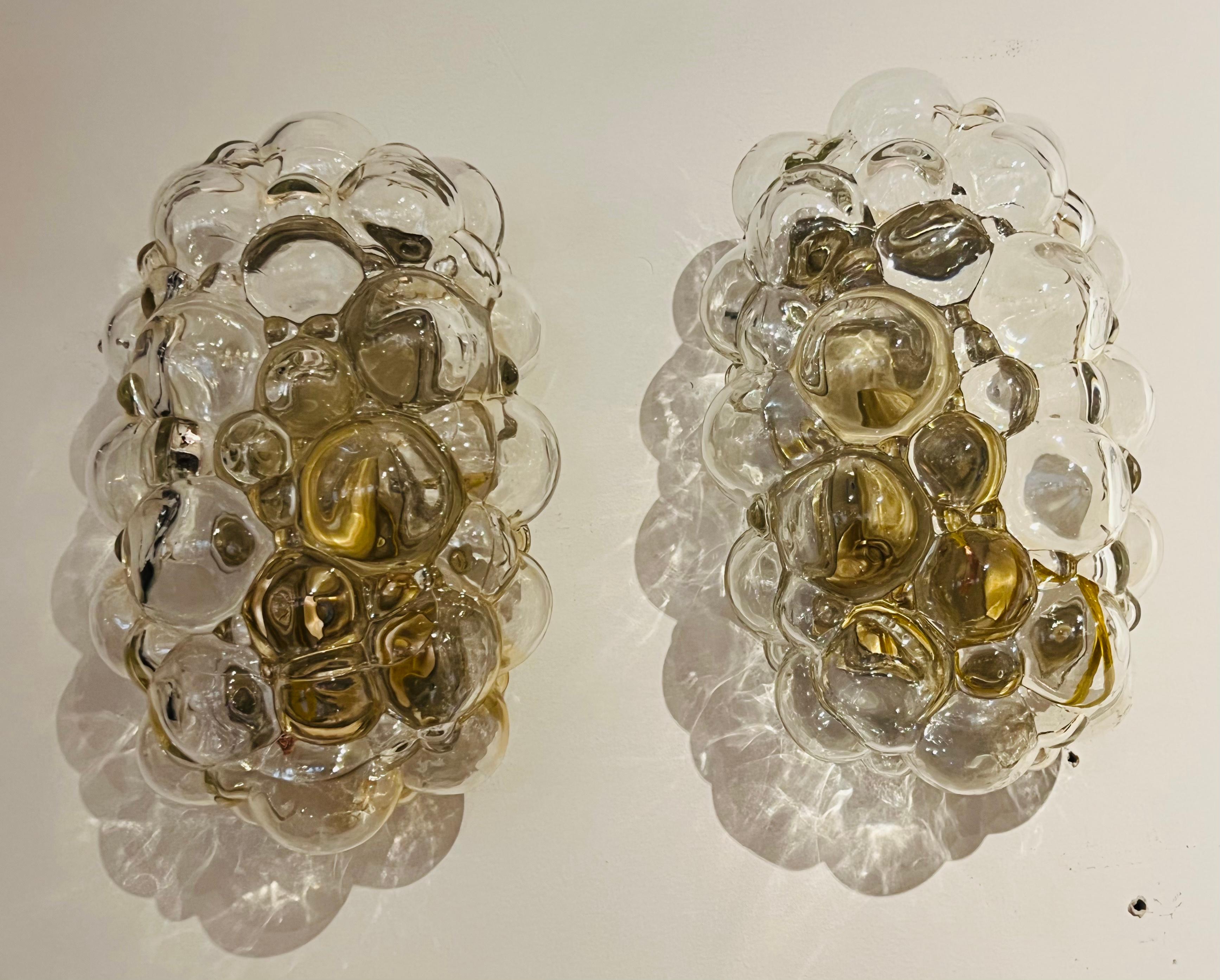Ein Paar Wandleuchten aus den 1960er Jahren mit mattgoldenen Armaturen, die leichte Strohblasenglasschirme halten. Hergestellt von Helena Tynell für Limburg. Neu verkabelt.