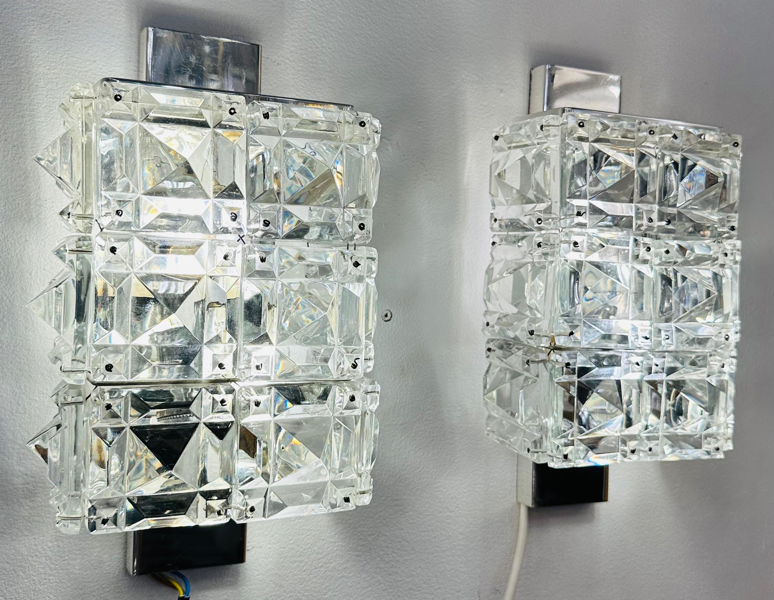 Pair of Austrian wall sconces manufactured by Kinkeldey in Austria during the 1960s. The cut crystal star faceted and chromed metal.1960s   The rectangular cut crystal glass shades slot onto a thin rectangular chrome plated frame which also holds
