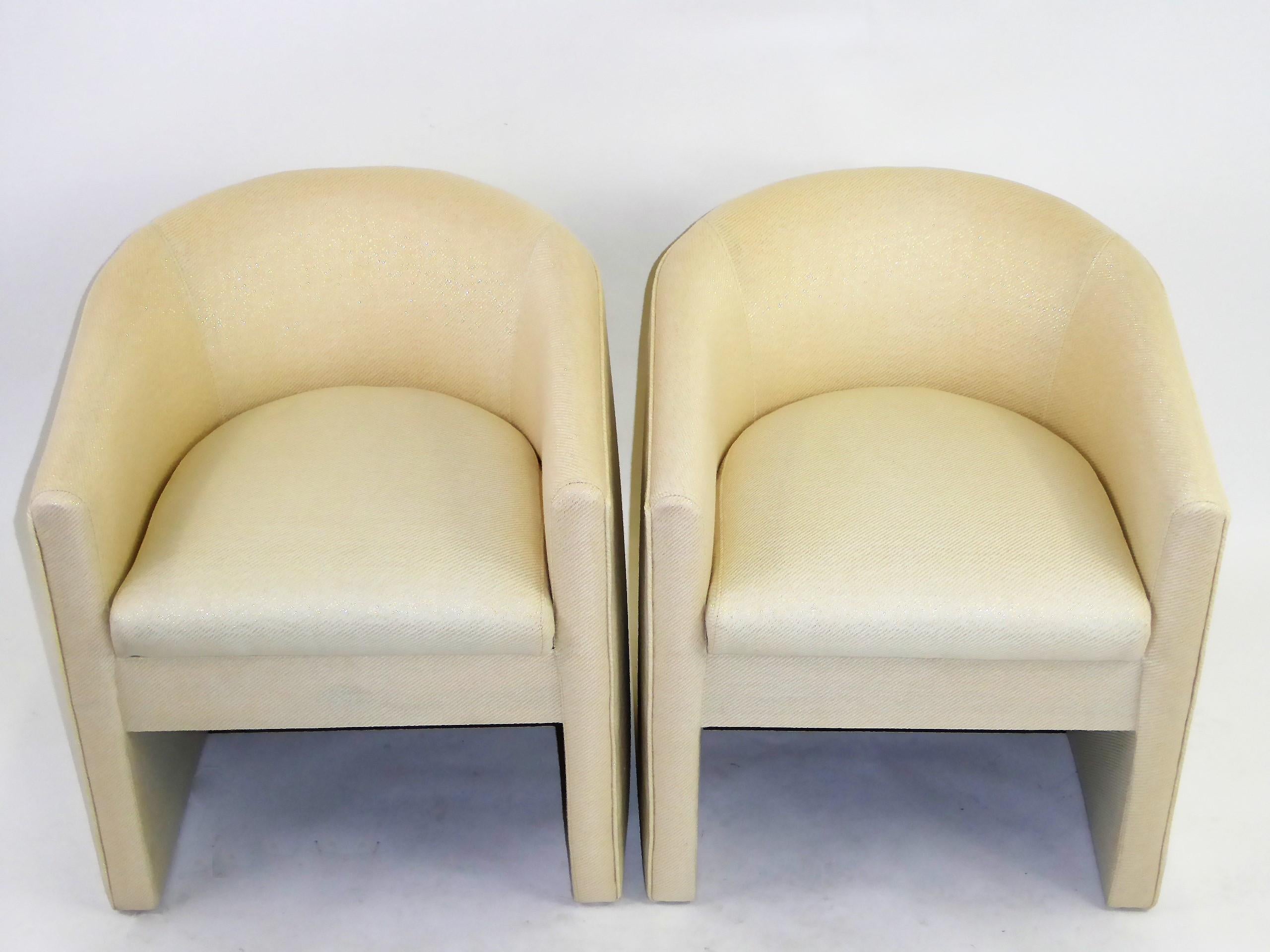 Wonderful pair of 1960s barrel back tub chairs newly upholstered in a creamy white woven fabric with gold threading. Inspired by the designs of Milo Baughman, Ward Bennett and Harvey Probber who all did variations of this chair. Great footprint and