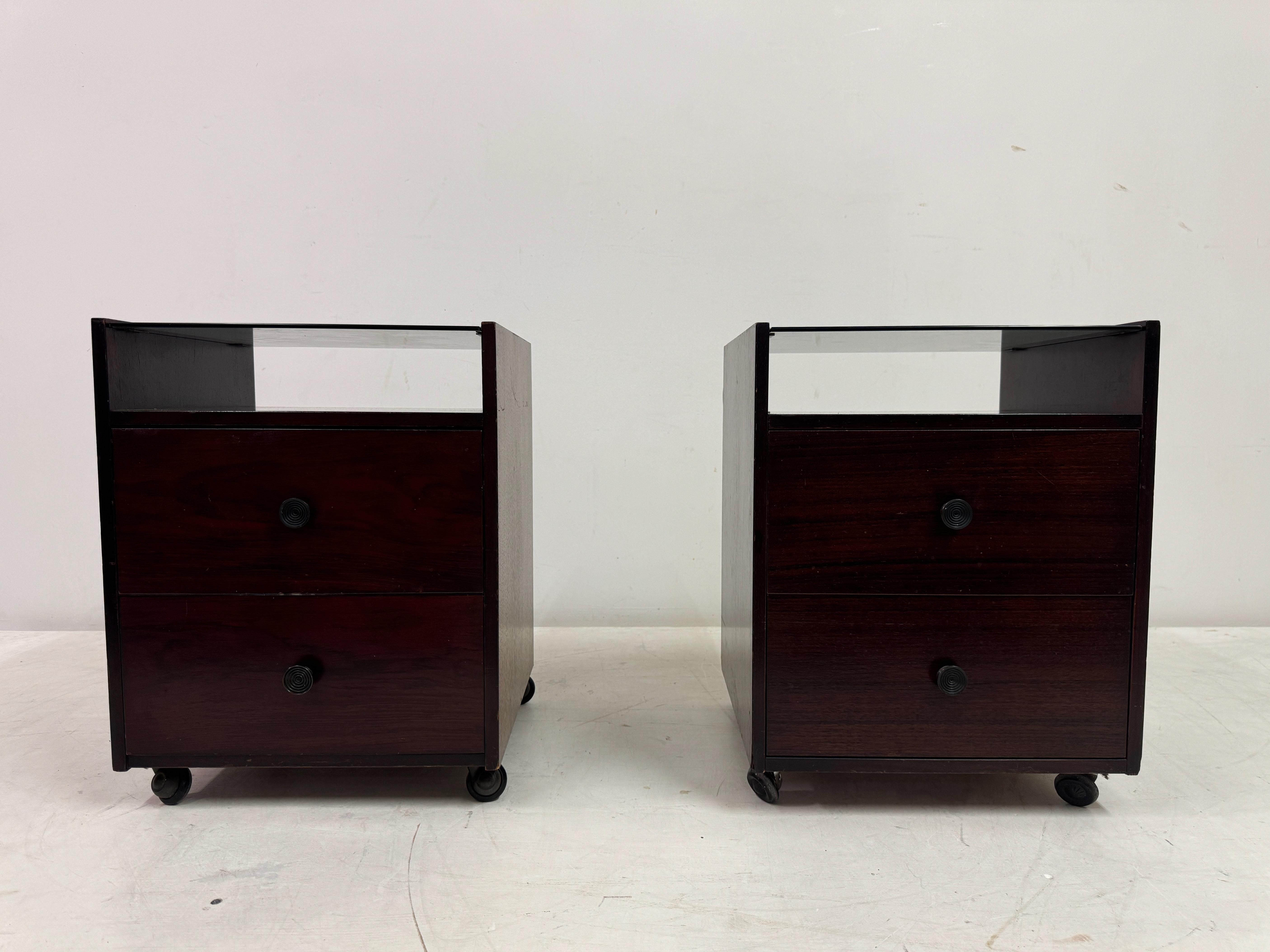 Pair of bedside cabinets

By Carlo de Carli 

For Sormani

Two drawers

Glass top shelf

Chip to one piece of glass

One cabinet has black castors and the other has silver

Italy 1960s

These elegant nightstands, designed by the renowned Italian