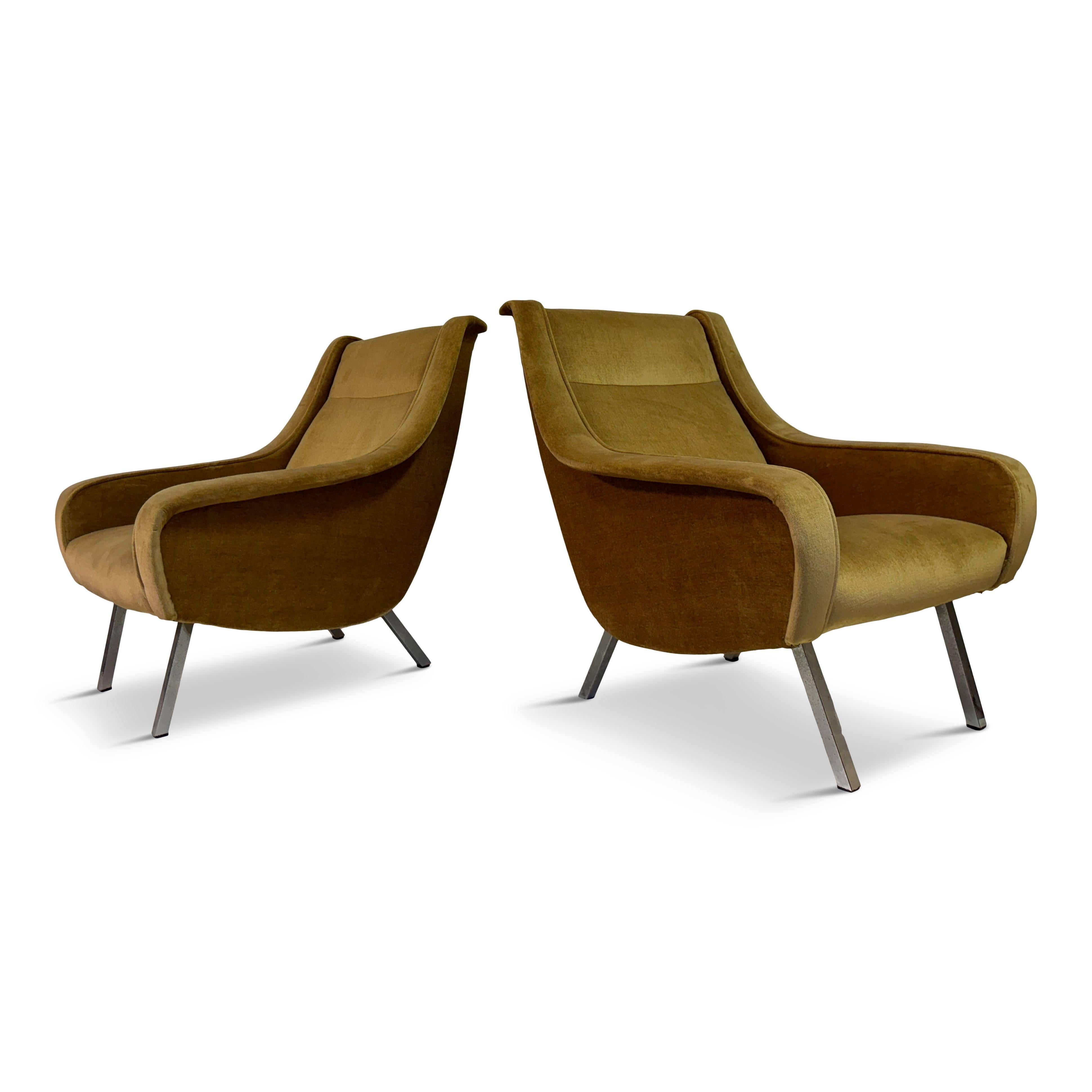 These armchairs are a pair of Belgian midcentury modern pieces from the 1960s. 
The armchairs have a sleek, streamlined silhouette typical of midcentury modern furniture. The arms flow seamlessly into the backrest, creating a continuous and