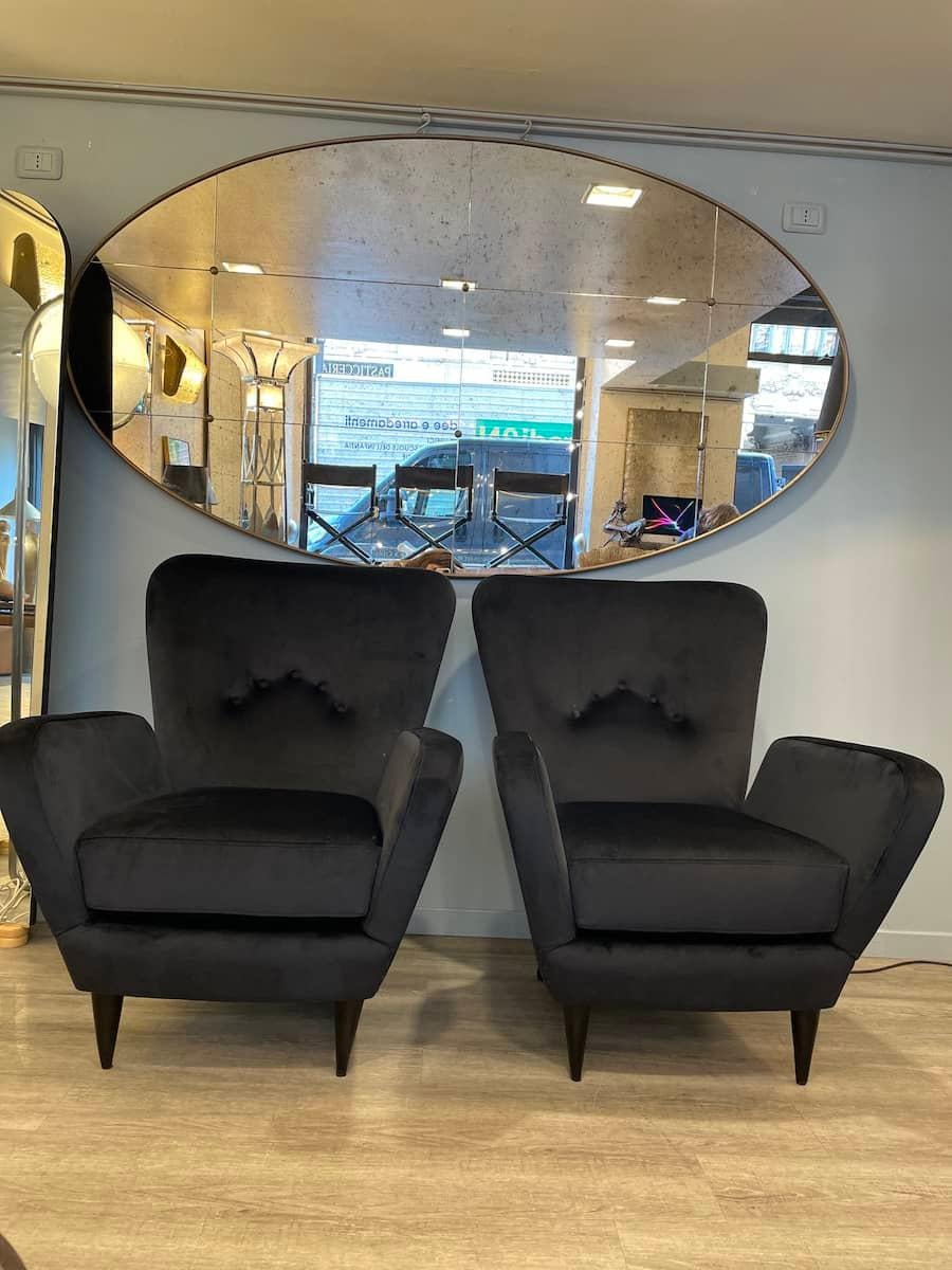 Pair of black 1960s armchairs reupholstered in black velvet. The armchairs have the fabric fixed with studs, both in the side and in the back of the seat. The armchairs are also suitable to be placed in the centre of the room, in different types of