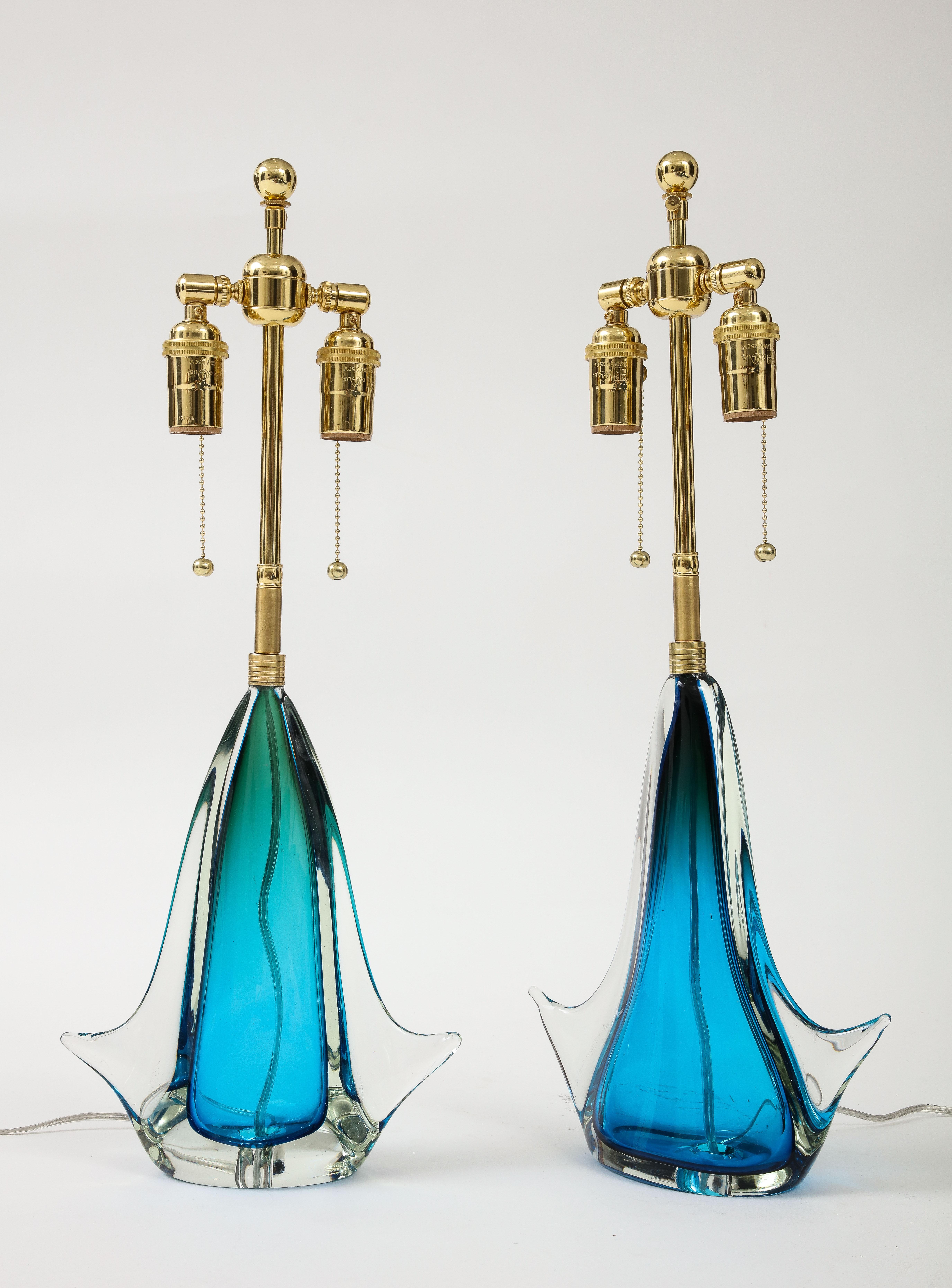 Paire de lampes en verre de Murano soufflé à la main, d'une couleur bleue étonnante.
Les lampes ont été nouvellement câblées avec des doubles grappes réglables en laiton poli qui acceptent des ampoules de taille standard.
Comme pour tout verre