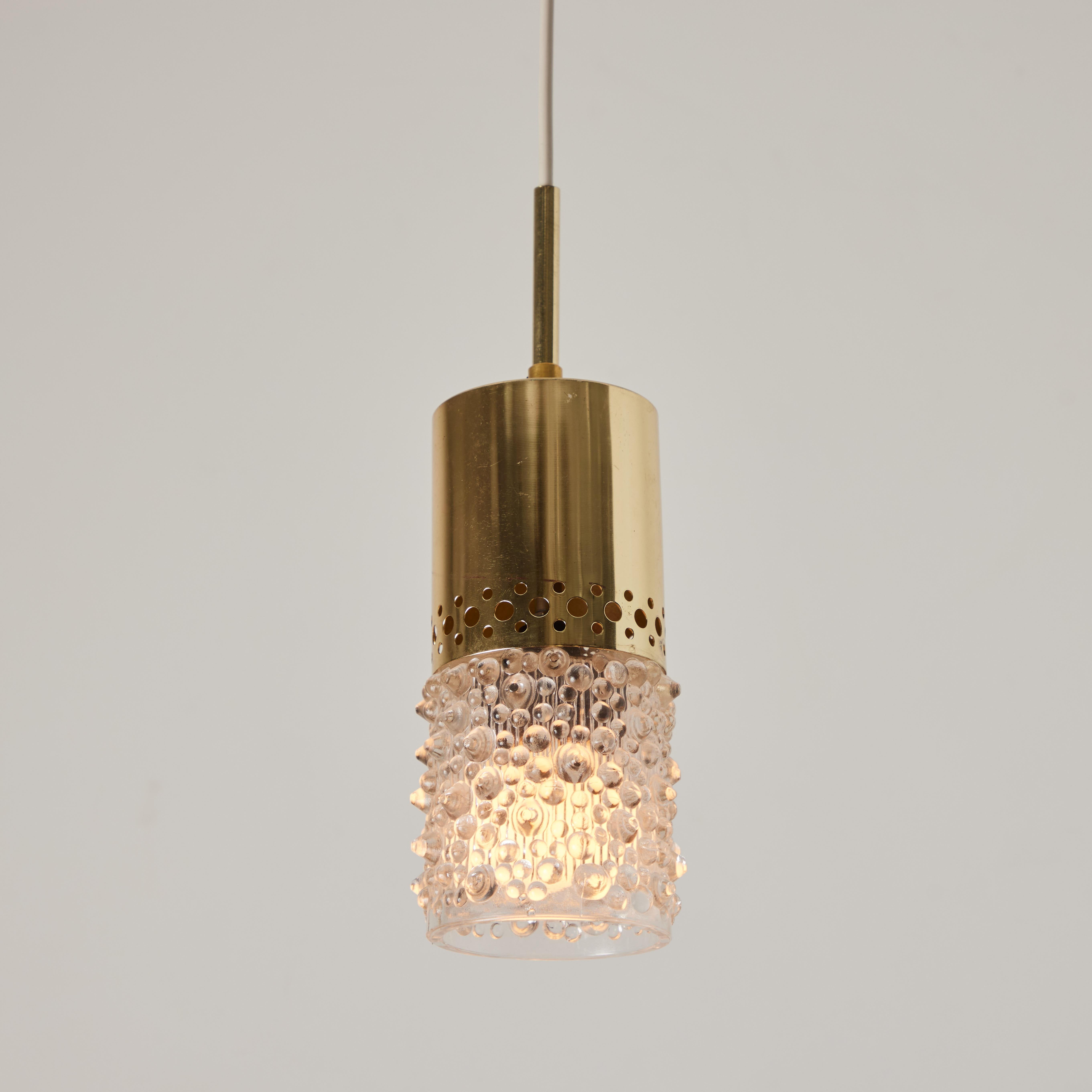 Pair of 1960s Brass and Bubble Glass Pendants by Helena Tynell.

Executed in thick and heavy sculpturally textured bubble glass with perforated polished brass mount and ceiling canopy. Fabricated in Limburg, Germany circa 1960s. Unmarked.

Helena