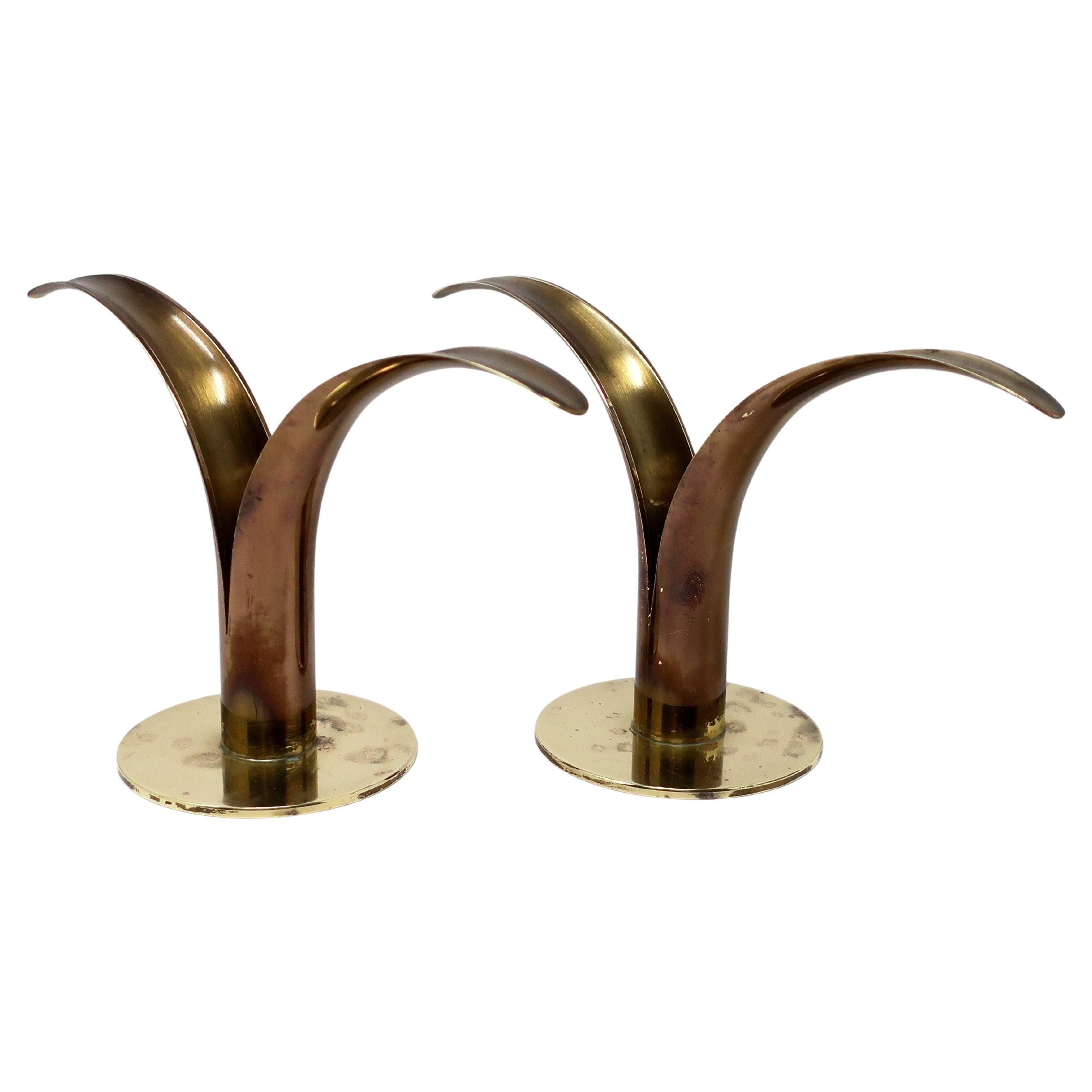 A pair of Scandinavian Modern brass Lily / Liljan candlesticks designed by Ivar Ahlenius Bjork for Ystad Metall in Sweden and irst exhibited in the US at the Scandinavian Pavilion of 1939 New York World's Fair.  

In vintage condition with patina