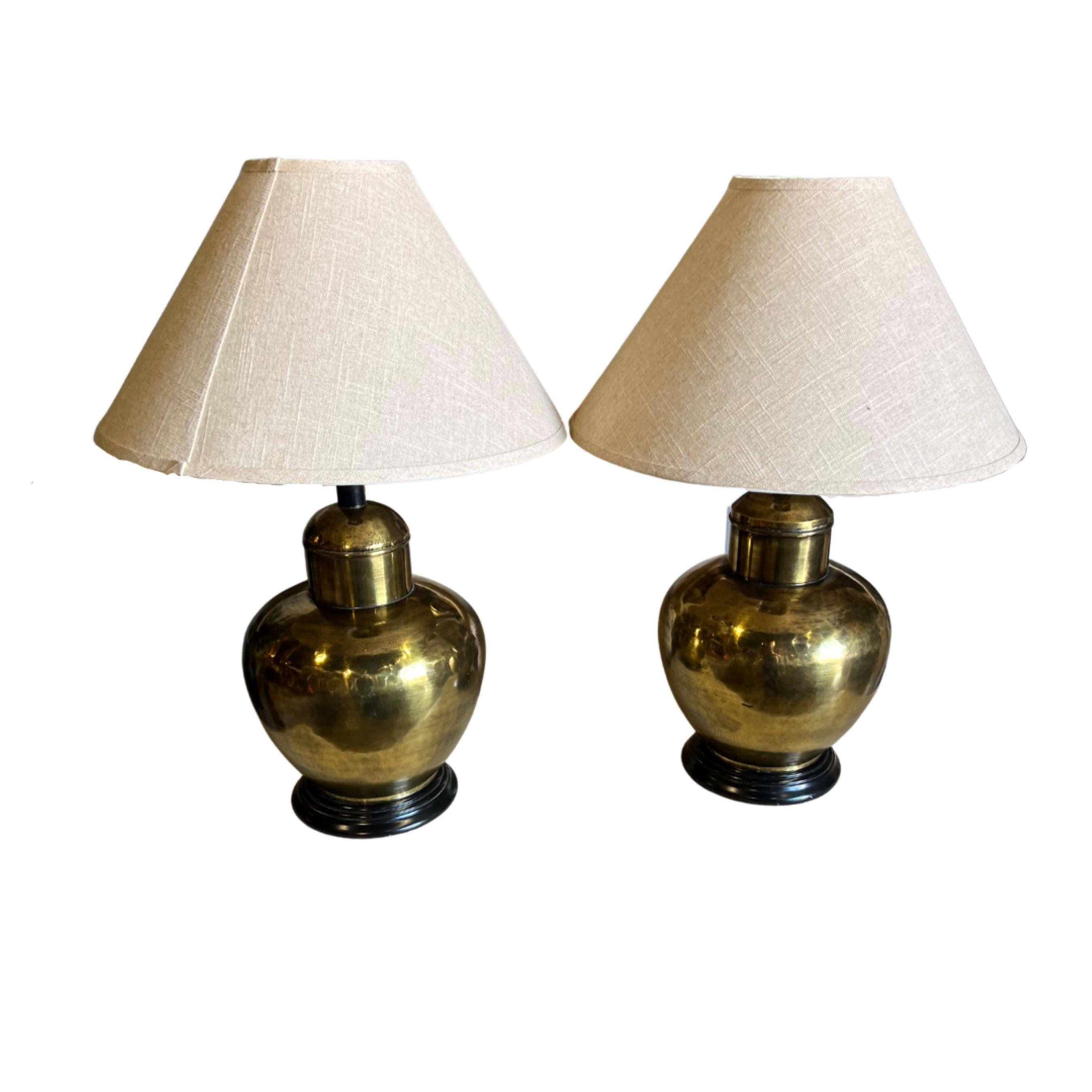 Vintage
1960's
Pair of brass lamps with black base.
Brand new fine burlap lamp shades
In overall good working condition with no dents or noticeable marks or nicks
Wear is consistent with age and use.

Lamp Overall 
 Height: 27