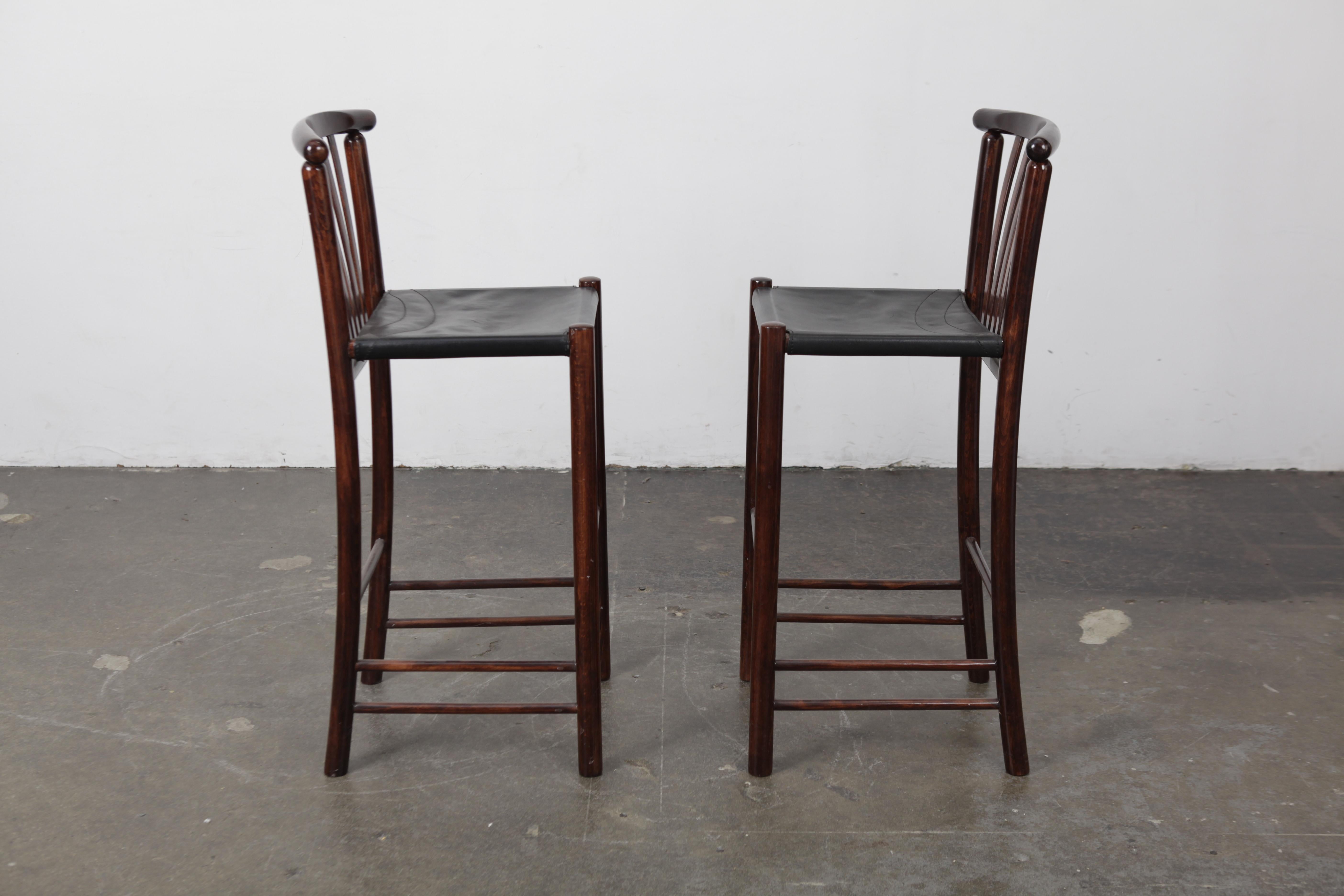 Pair of tall solid wood spindle back bar stools with original black leather seats, Brazil, 1960s. Original black leather slings. These are bar height.