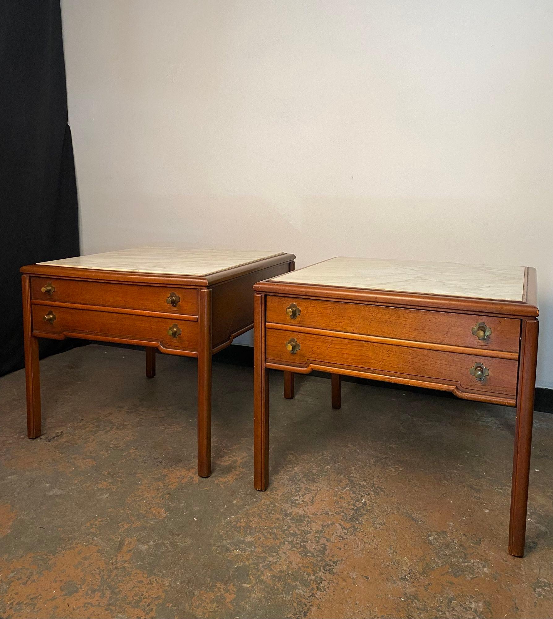 A beautiful pair of Carrara Marble topped end tables made in the 1960's by Imperial Furniture in Grand Rapids Michigan. Featuring carved walnut details and brass hardware these will look amazing in your home.