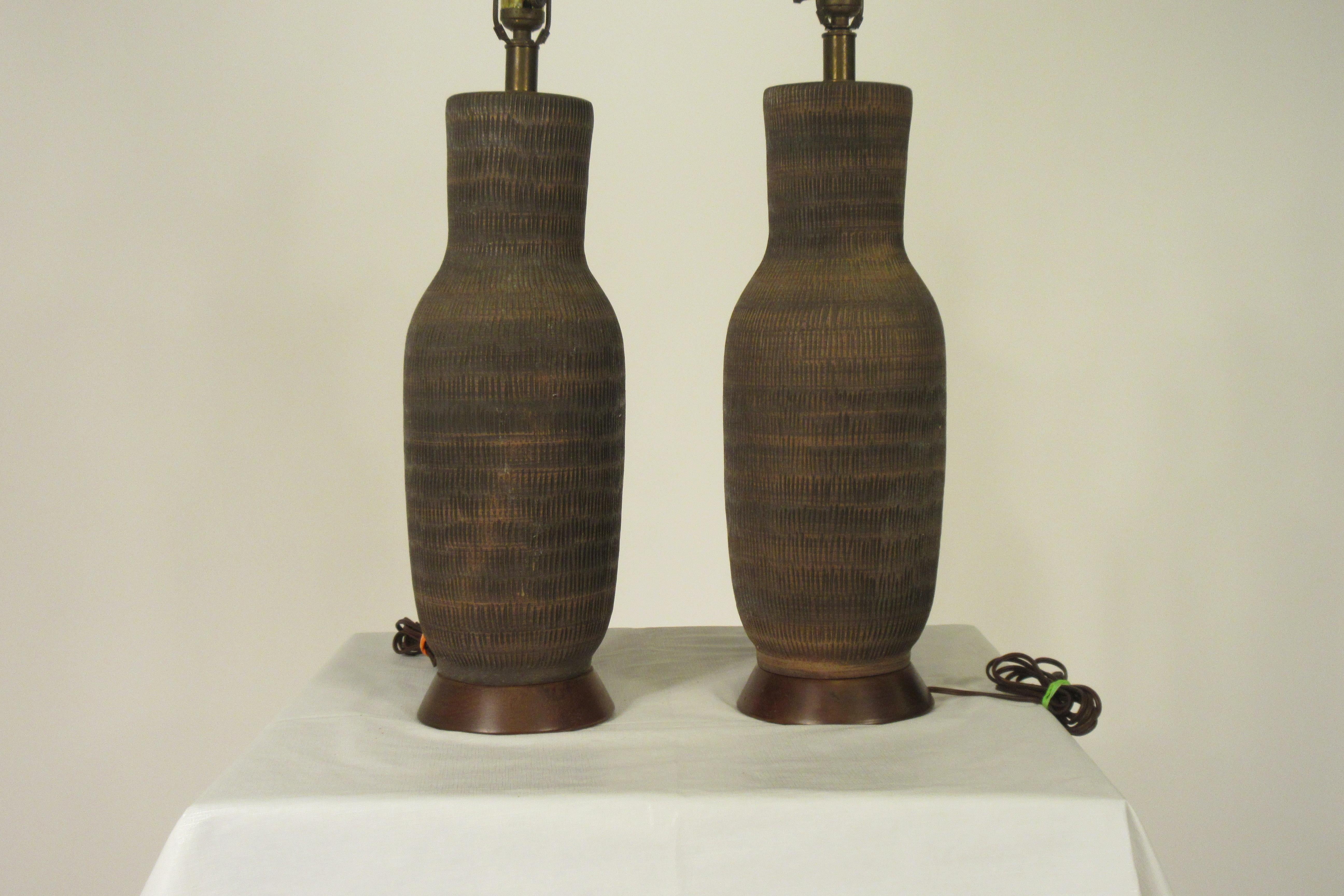 Pair of 1960s ceramic textured table lamps on wood bases.