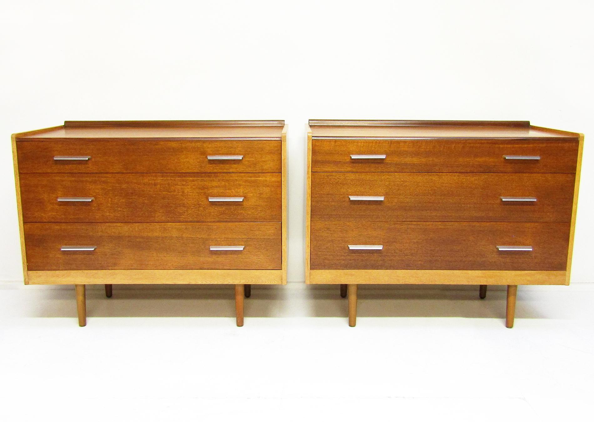 A rare pair of 1960s chests of drawers in teak, oak and steel by John & Sylvia Reid for Stag.

Similar to Hans Wegner designs, they contrast rich teak with oak wood. The metal handles add a sense of architectural minimalism.

They have been