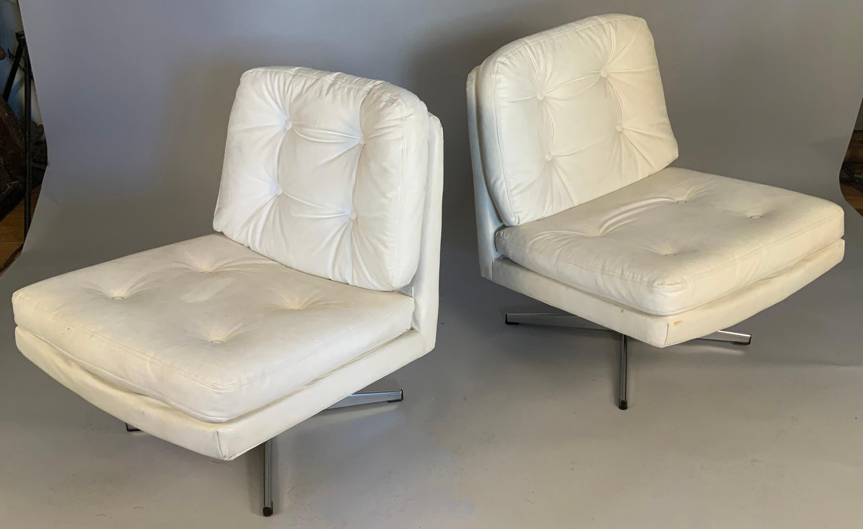 A pair of classic modern vintage 1960's swivel lounge chairs, on chrome star bases. Beautiful scale and very comfortable. In their original white vinyl upholstery, which shows average wear for the period. Marked made in Sweden.