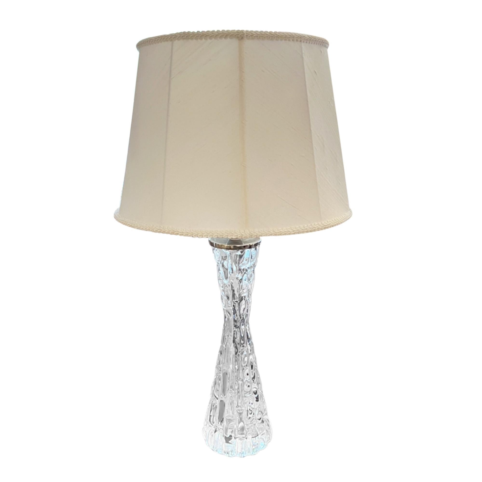 Une belle paire de lampes Orrefors en verre clair, estampillées et signées.

Depuis 1898, Orrefors produit d'élégants articles en verre dans ses ateliers de Smäland, en Suède. Ce style a été conçu par Carl Fagerlund.

Illustré avec des abat-jour en