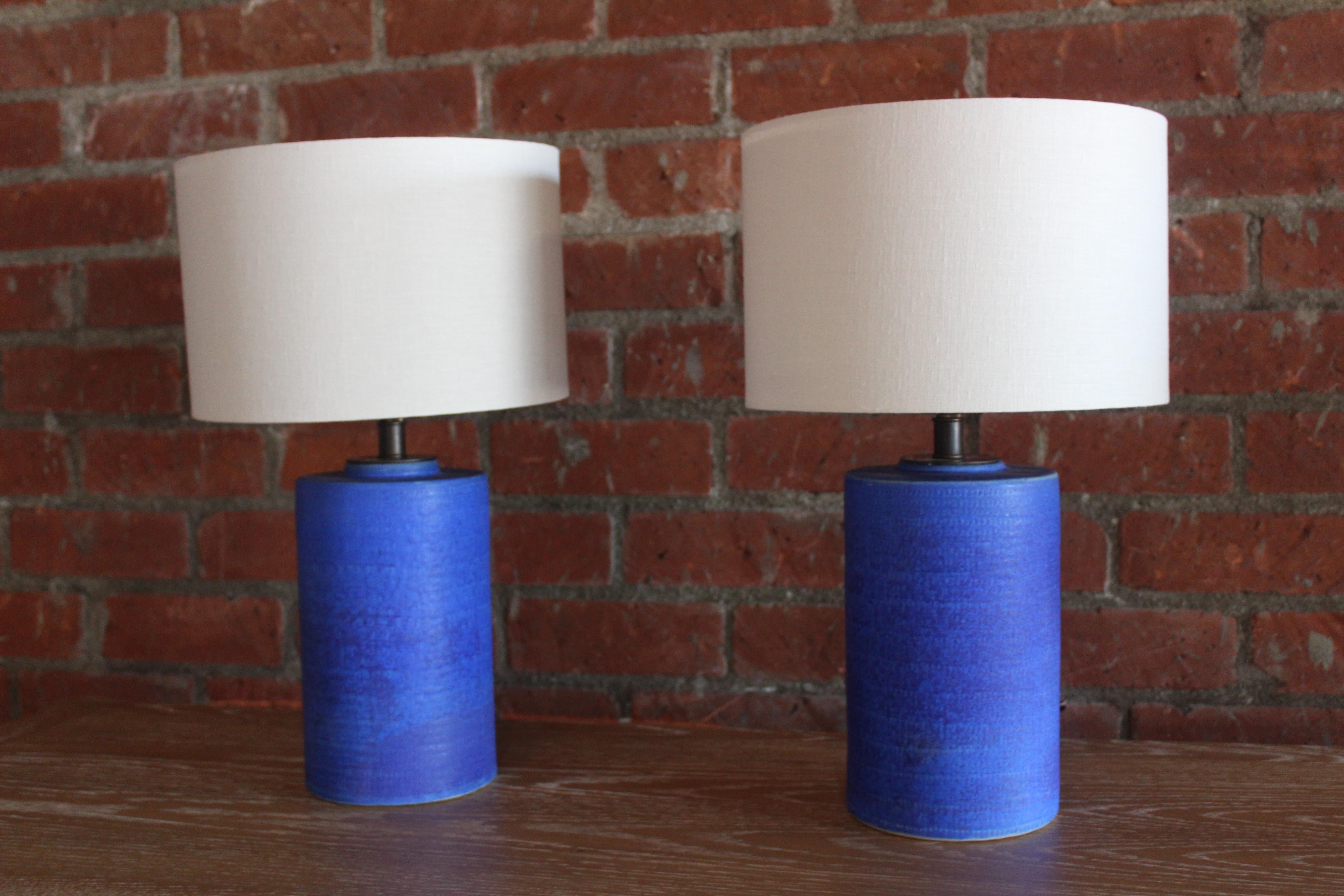 Pair of 1960s ceramic table lamps in cobalt blue. Newly rewired and fitted with custom made lamp shades in Belgian linen. Measures: The lamps are 20.5
