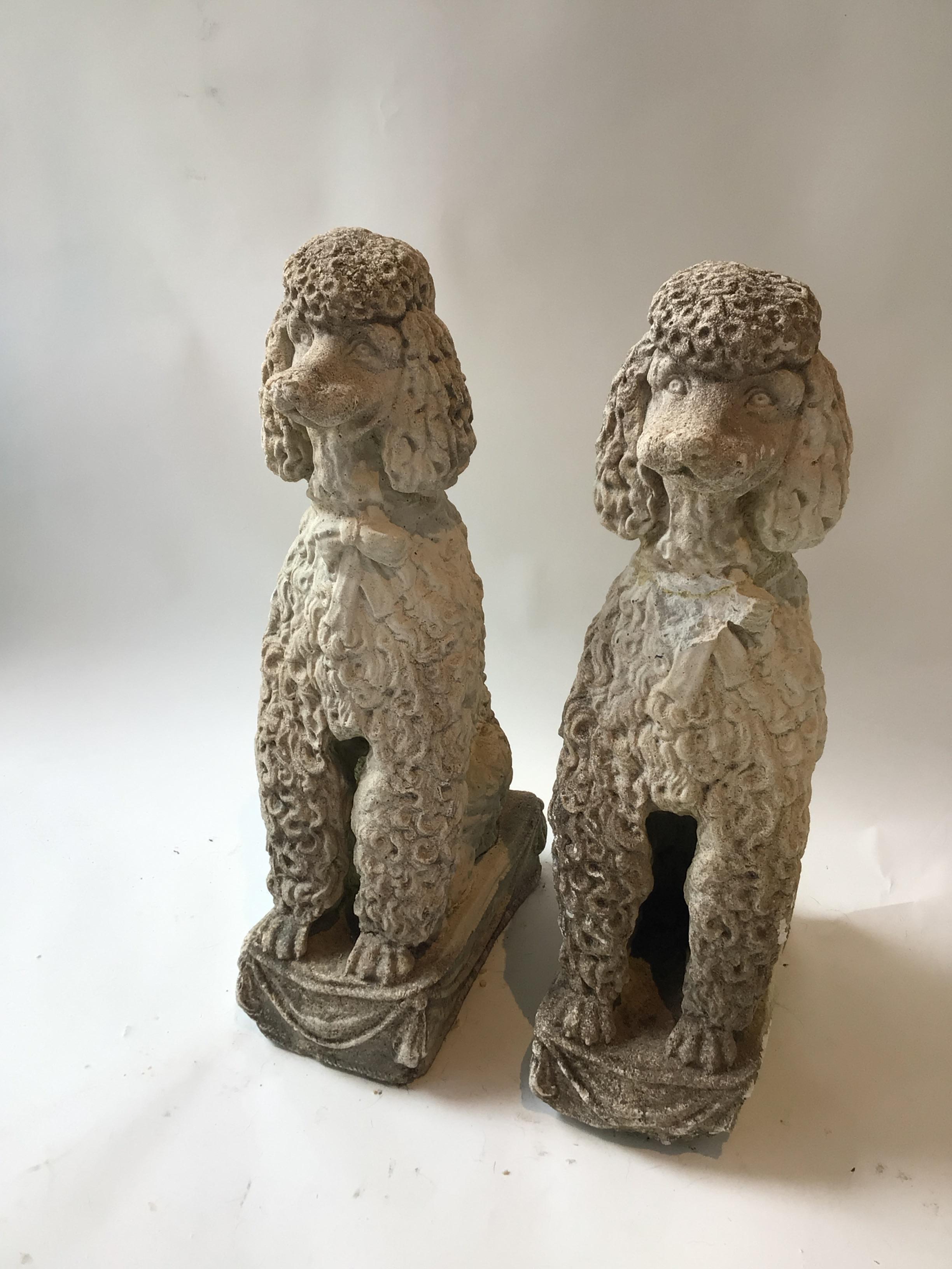 Pair of 1960s concrete poodles. One poodles head was detached. It has been glued back on. As shown in the last 2 pictures. One bow tie is missing some concrete.
