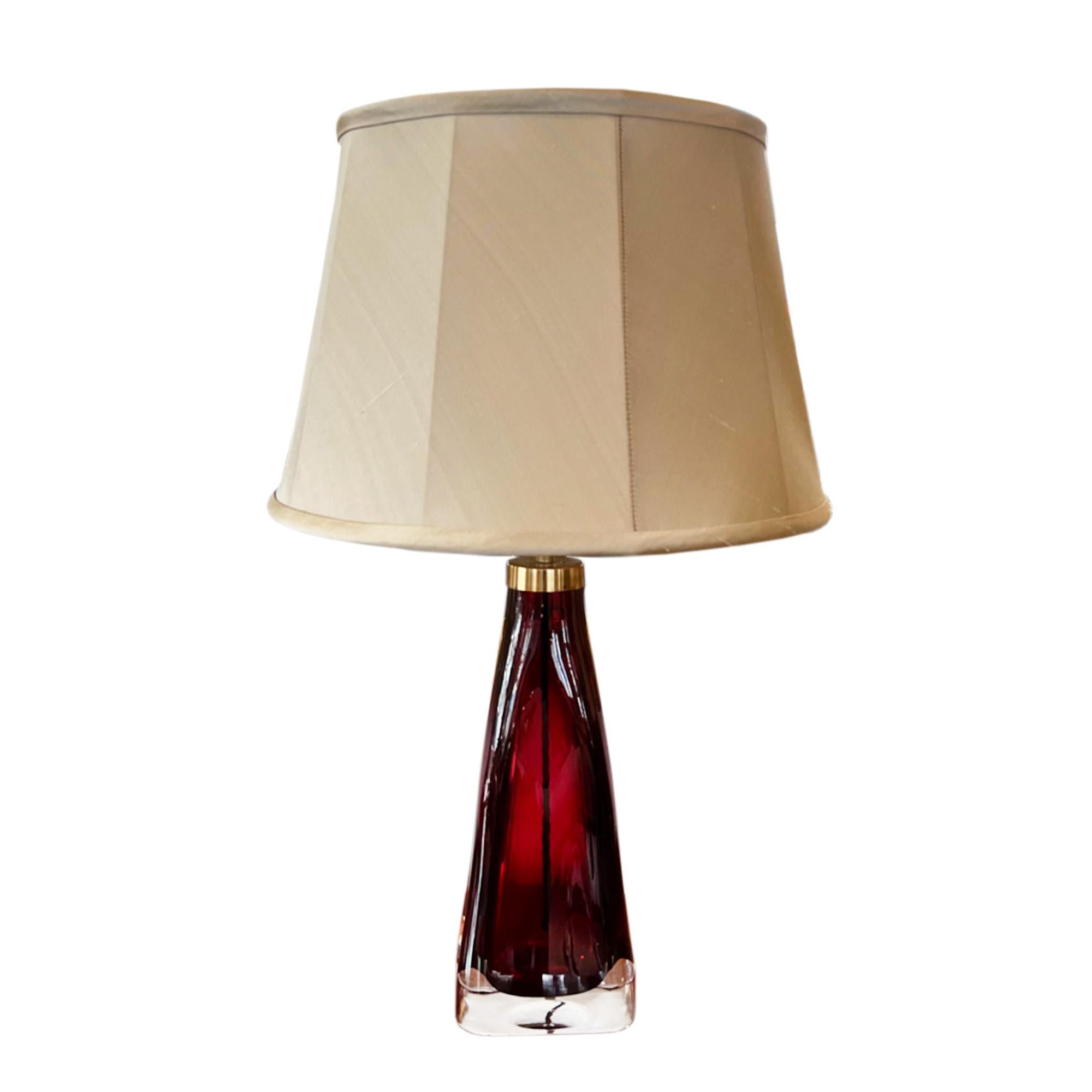 A pair of glass table lamps, by Orrefors, in a lovely cranberry colour with triangular shape. Stamped with maker's name. 

Orrefors has been producing elegant glassware since 1898 at their workshops in Smäland, Sweden. This style was designed by