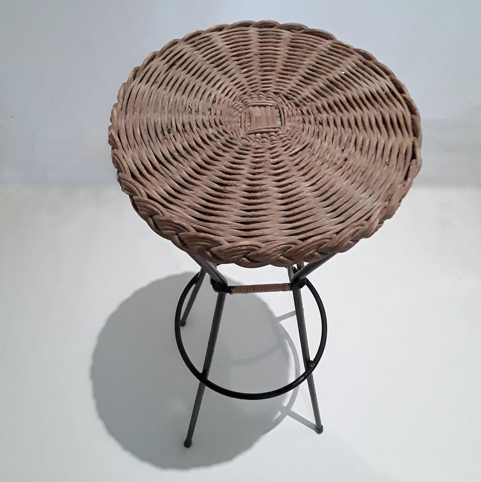 Two Mid-Century Modern bar stool shave a black metal frame and woven rattan seat, French, 1960s.