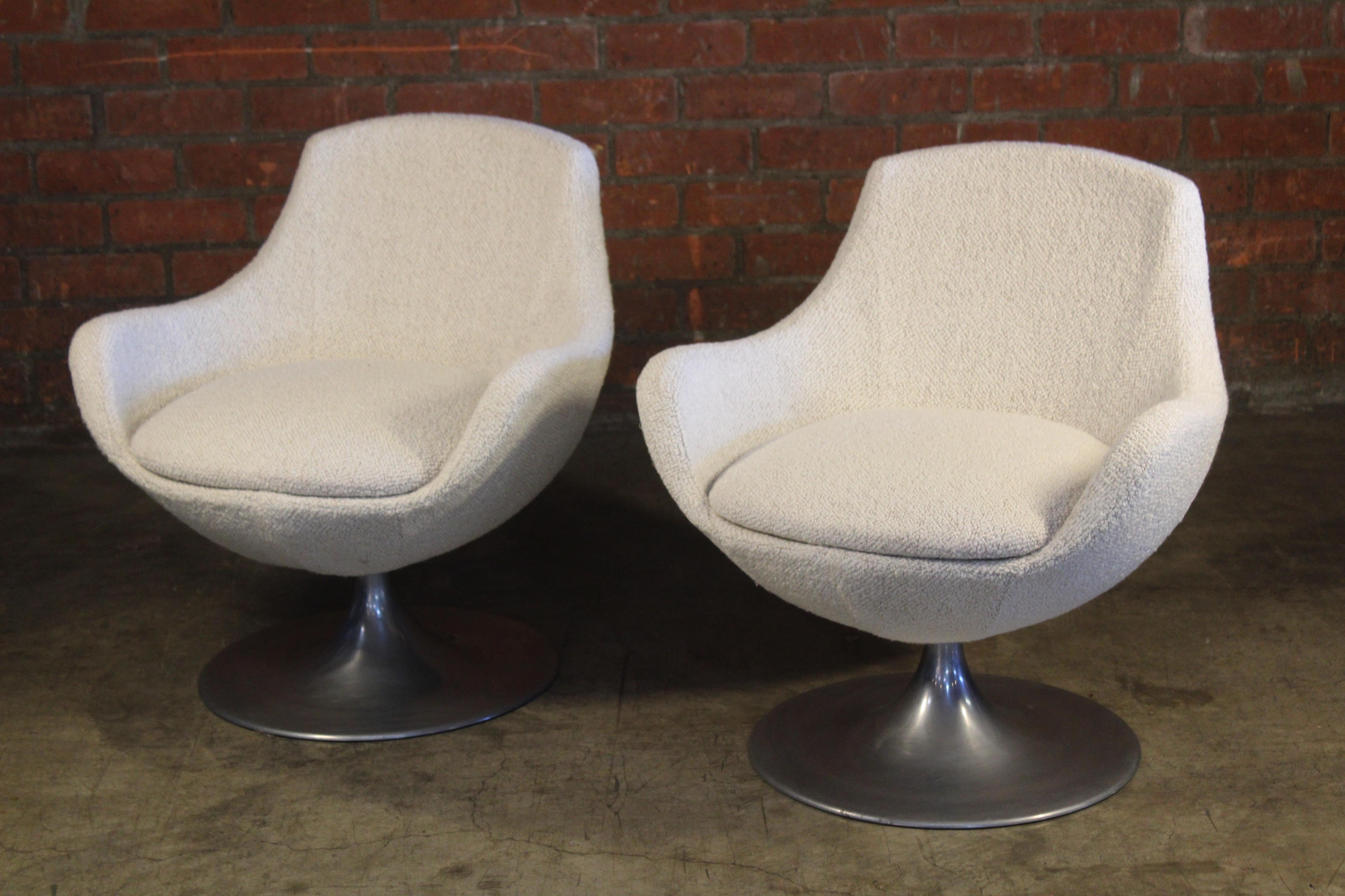 Pair of vintage 1960s swivel chairs, France. Newly upholstered in a white boucle. They sit on aluminum bases. Each chair is in good condition with only minimal wear to the base. Sold as a pair.