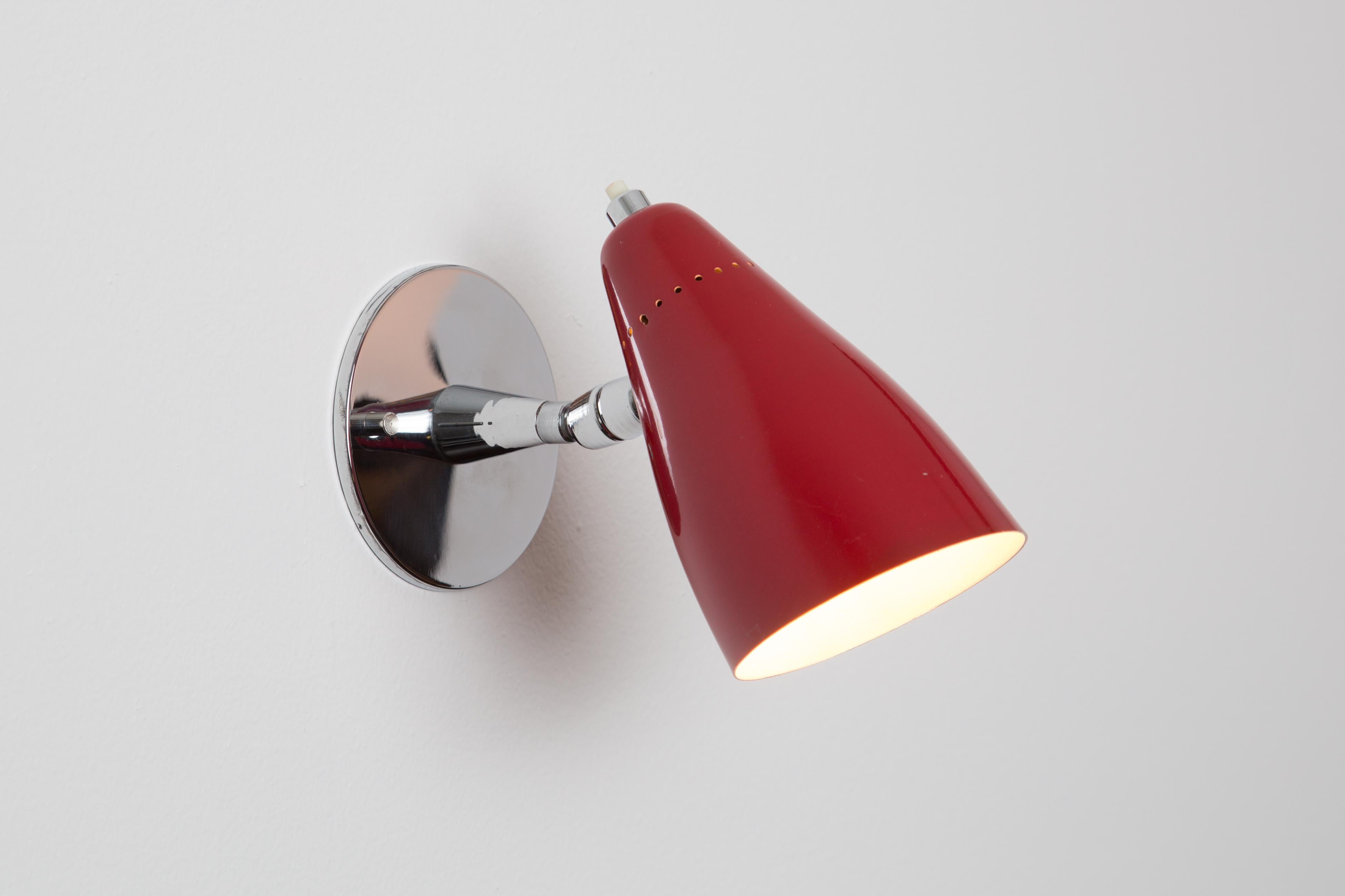 Pair of 1960s Giuseppe Ostuni Model #101 Red Articulating Sconces for O-Luce. Executed in polished chrome and red painted perforated aluminum shade. Sconces pivot up/down and left/right. An incredibly clean and refined design by one of the Italian