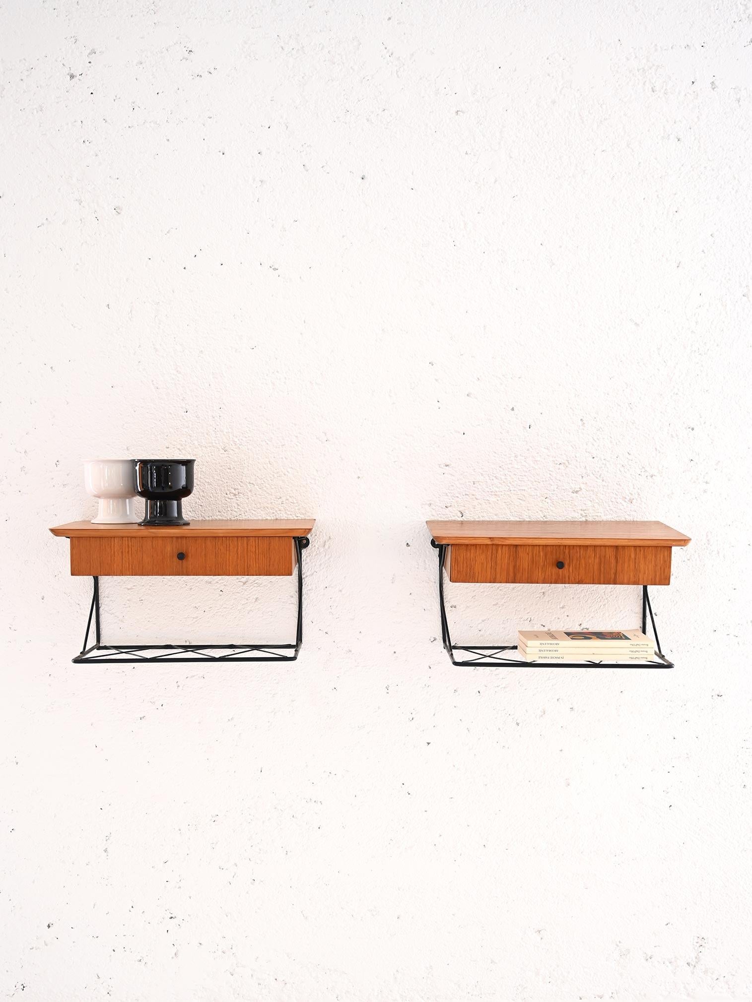 Scandinavian teak and metal bedside tables.

These modern furniture pieces trace the lines and taste of mid-century Nordic design. Formed of a teak top and drawer, there is also a black metal magazine rack top. The black knob detail on the drawers