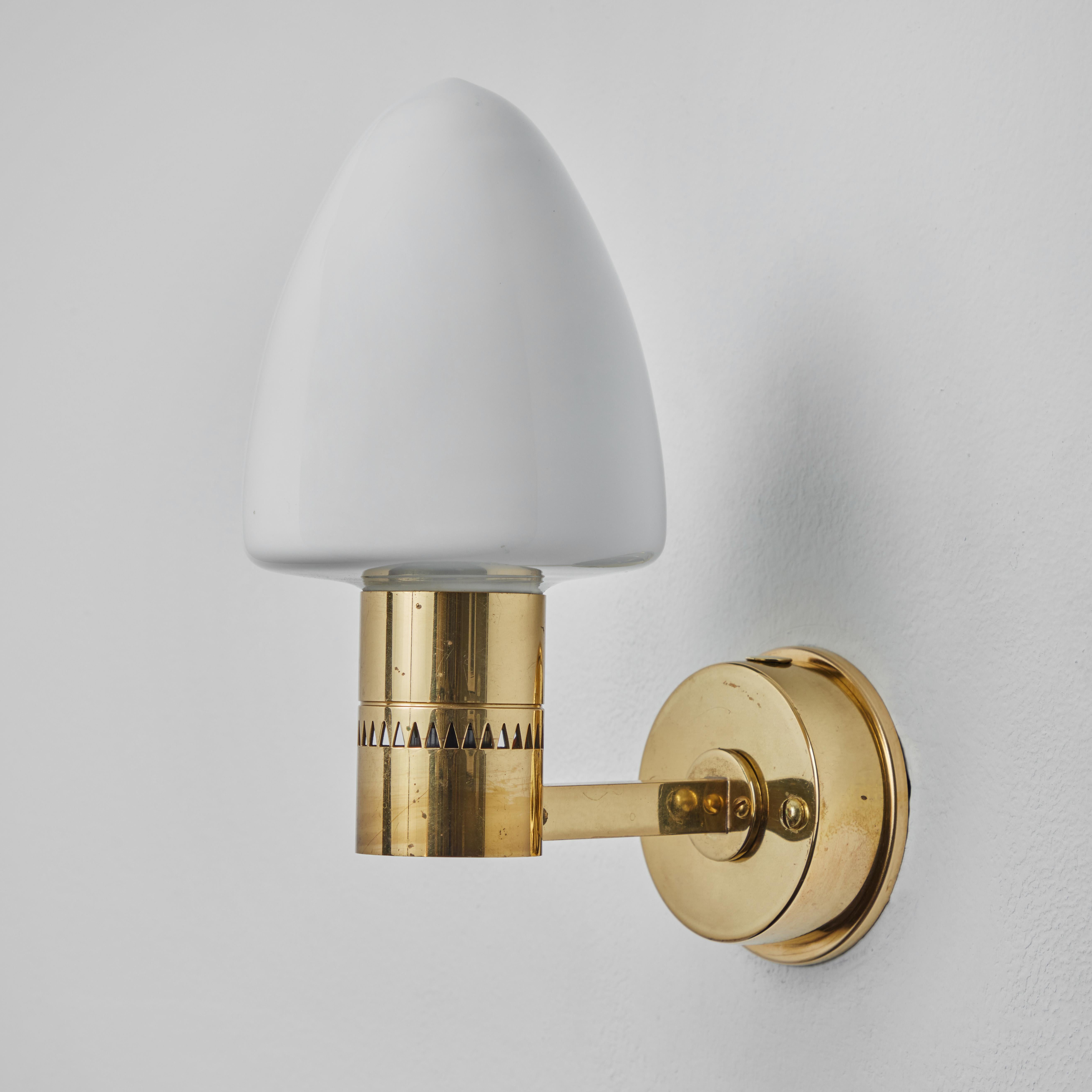 Pair of 1960s Hans-Agne Jakobsson Model V-220 brass & glass sconces for Markaryd. An incredibly refined vintage design that is quintessentially Swedish. Executed in sculpturally bent brass and blown opaline glass.

Price is for the pair.

Rewired
