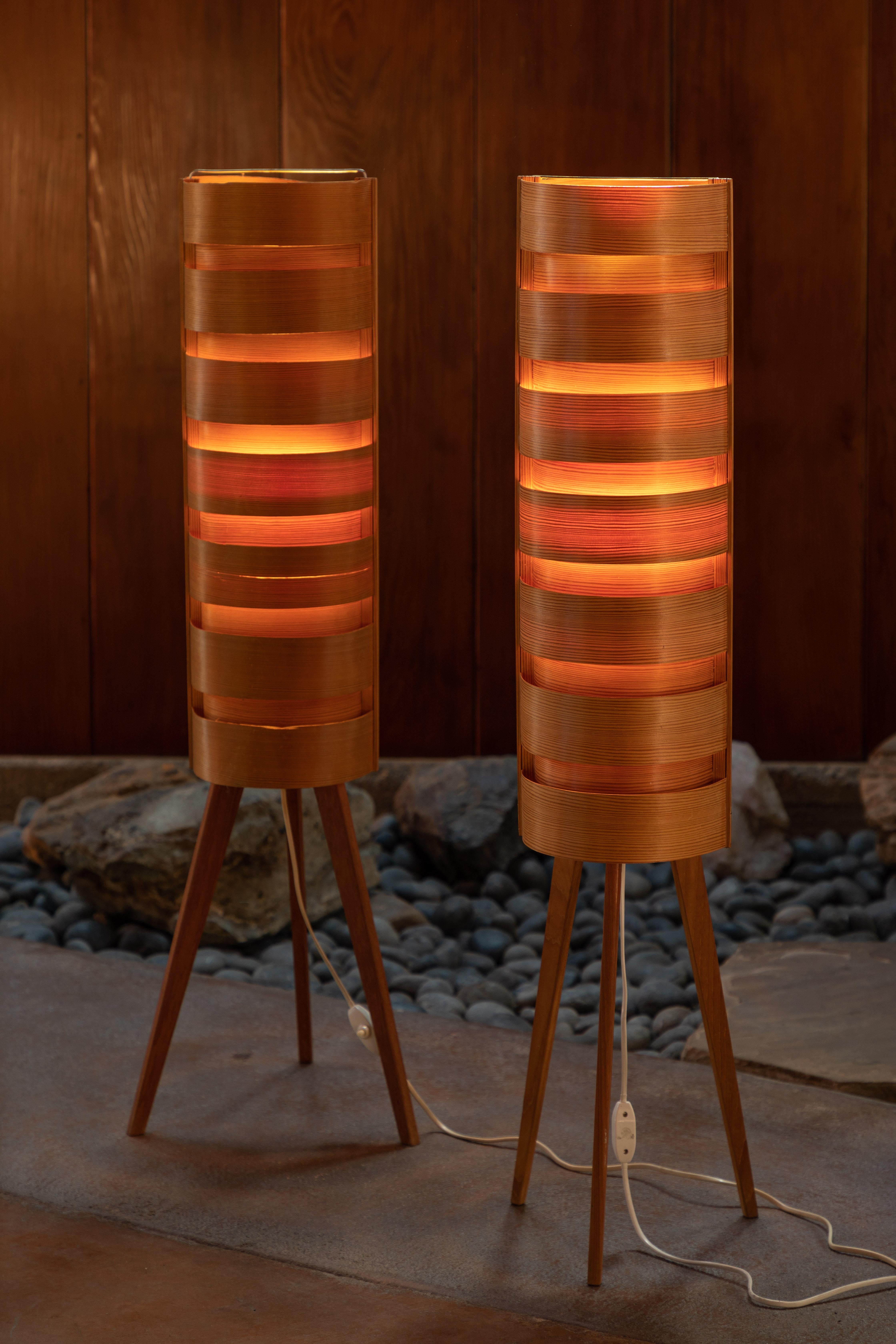 Pair of 1960s Hans-Agne Jakobsson wood tripod floor lamps for AB Ellysett. Designed and produced by Jakobsson in Markaryd, Sweden and executed in thin bentwood with solid wood tripod legs. A uniquely architectural and rare lamp that is so incredibly