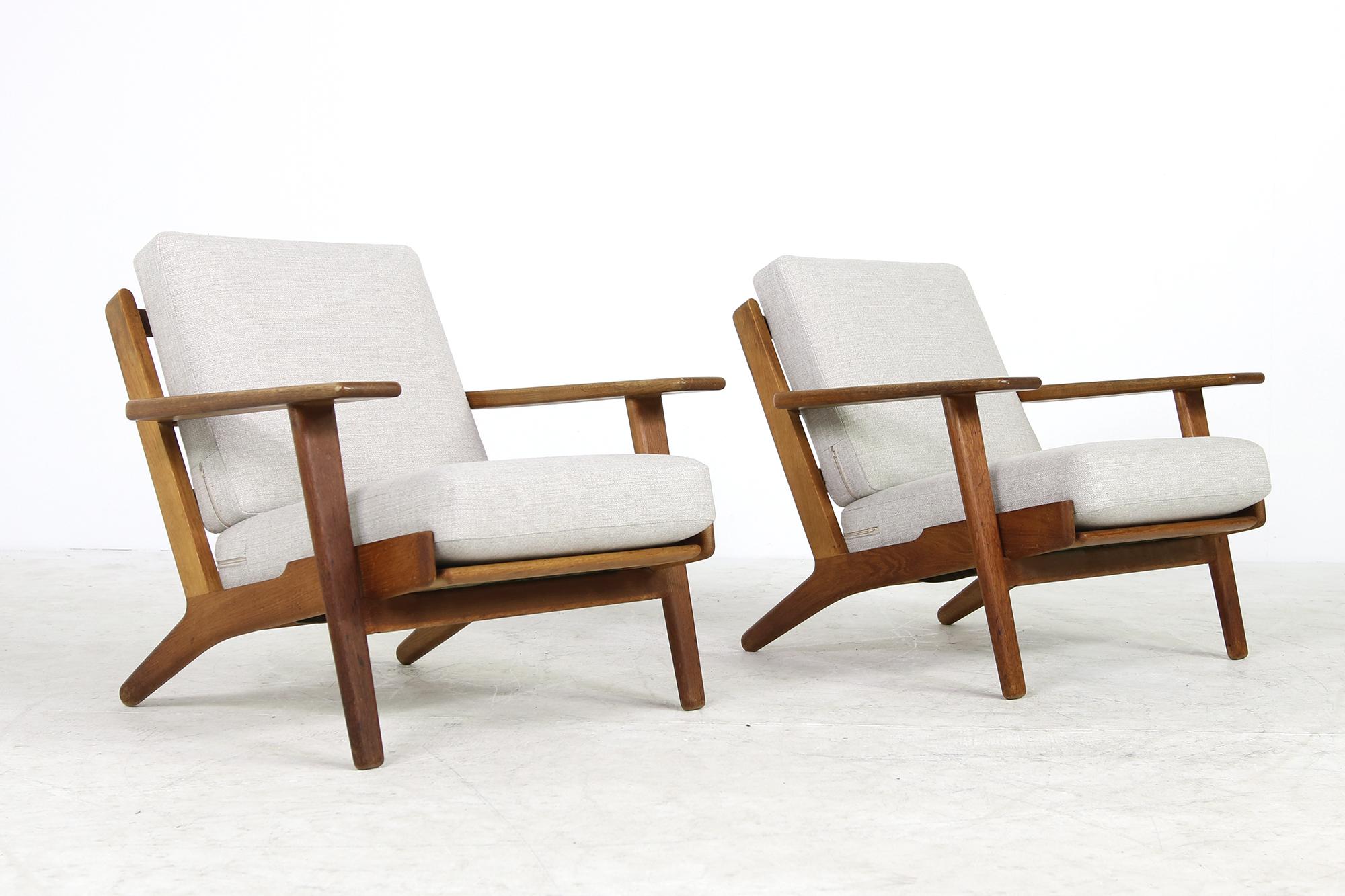 Beautiful pair of Mid-Century Modern Hans Wegner 1960s easy chairs, GETAMA GE 290 early edition, not the newer production.
New upholstery in best condition, covered with soft woven fabric in light grey.
 